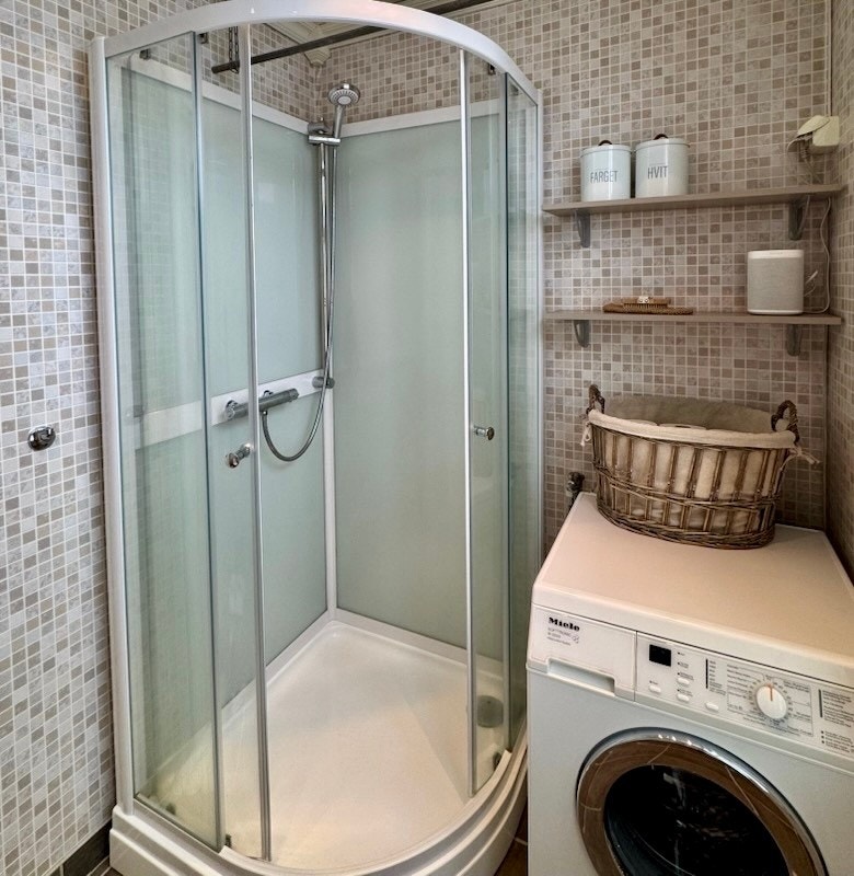 Dusjkabinett og røropplegg til vaskemaskin på bad. Galleribilde