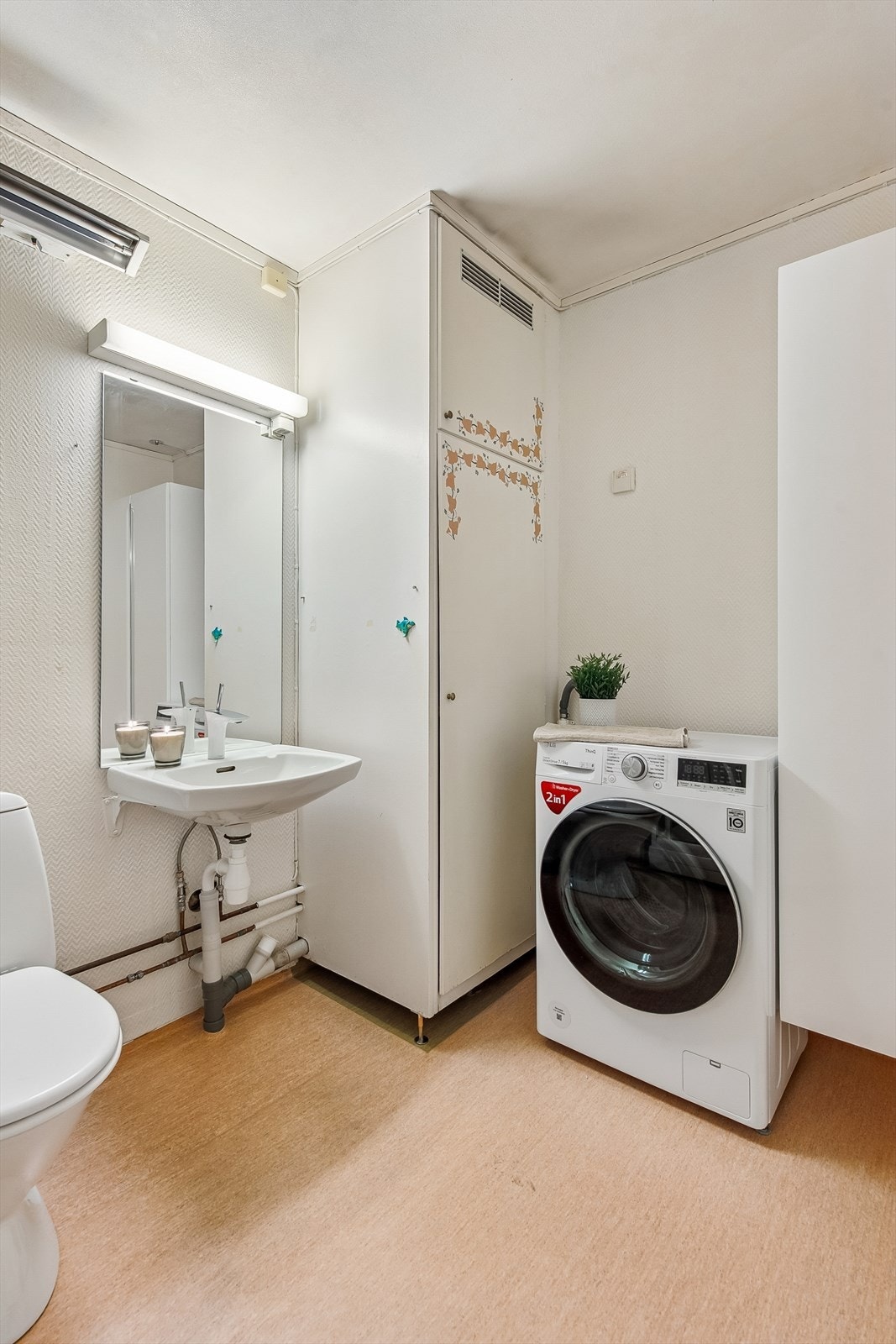 Badet er praktisk innredet med gulvmontert toalett, servant og opplegg for vaskemaskin. Galleribilde