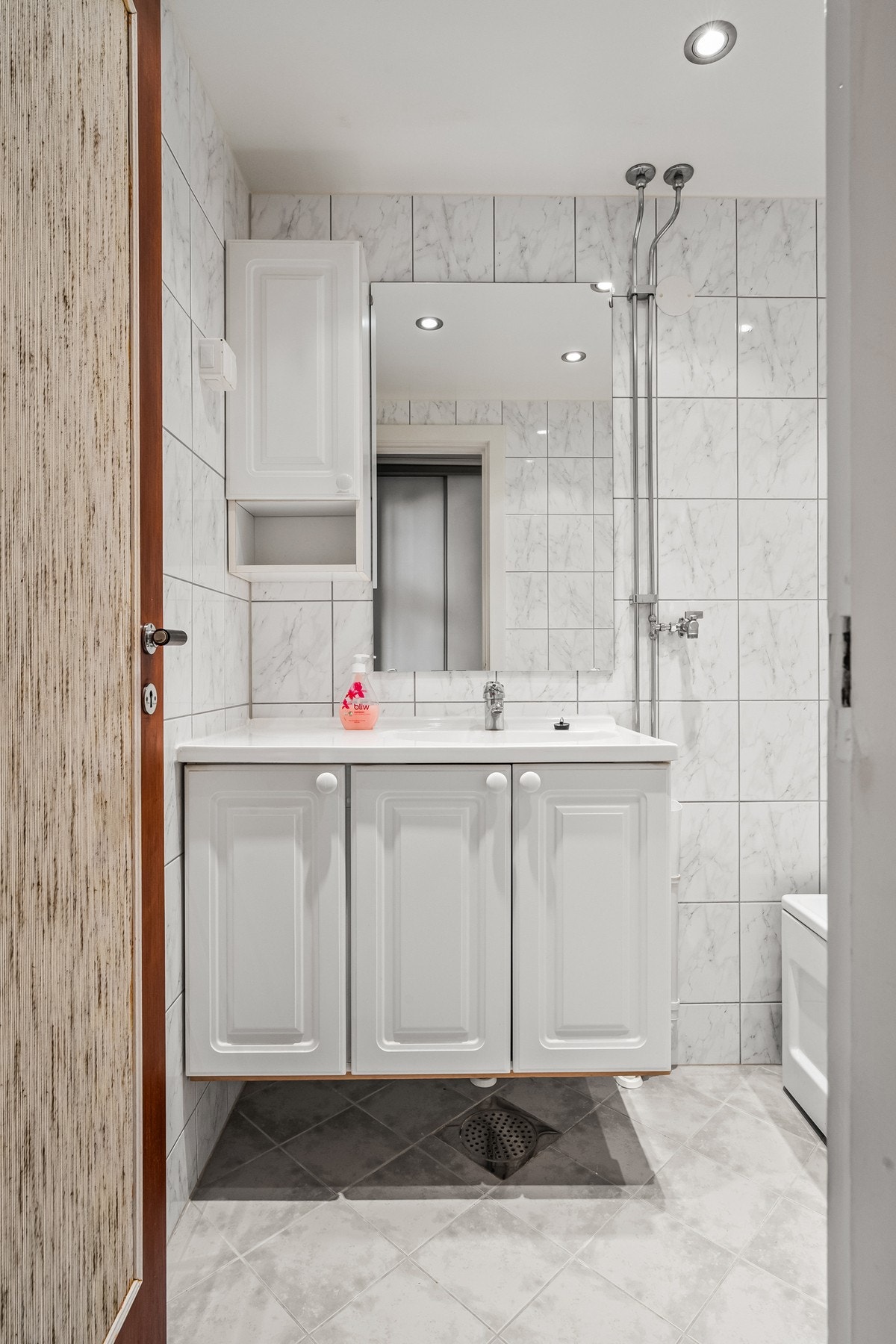 Den øvrige innredningen består av en heldekkende servant på hvitt skap og et speilskap. Galleribilde