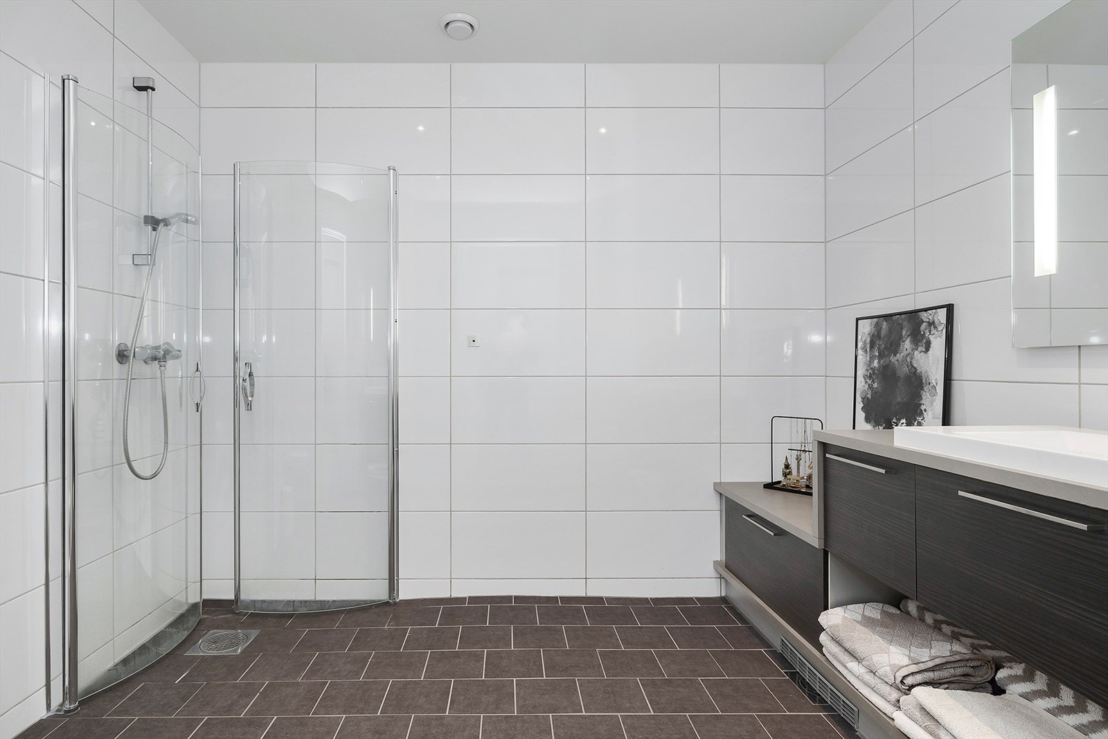 Innredet med dusjnisje i hjørnet, servantskap med finerte fronter og laminert benkeplate med nedfelt servant. Galleribilde