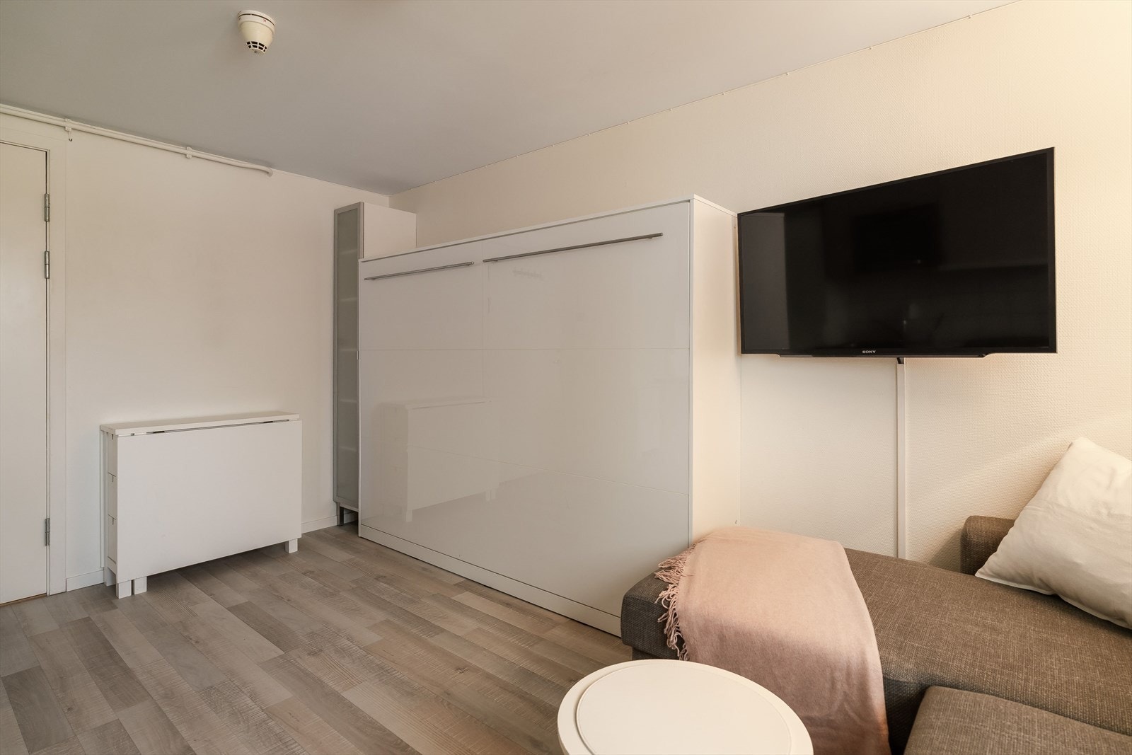 Her er det installert en vegghengt sammenleggbar seng som enkelt kan slås opp eller ned etter behov. Alt møblement og interiør følger med handelen. Galleribilde