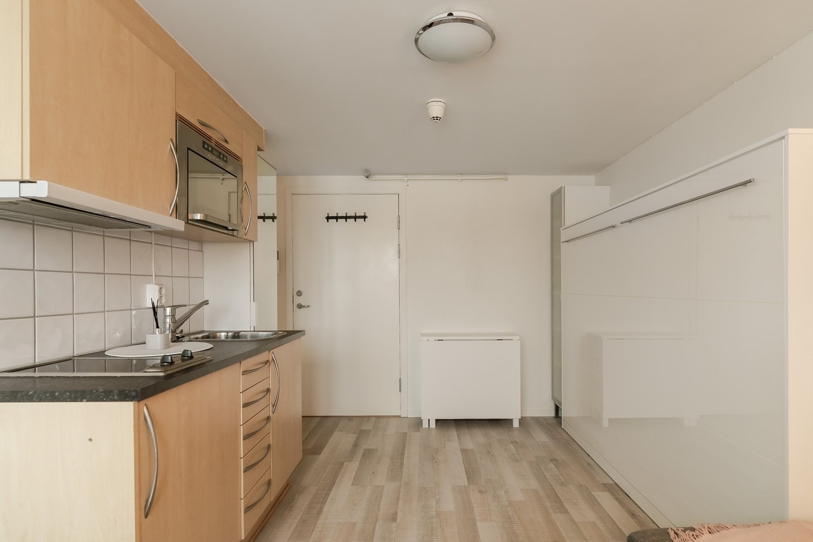 Kjøkkenet er praktisk innredet og har integrerte hvitevarer som platetopp, mikrobølgeovn og kjøleskap. Galleribilde