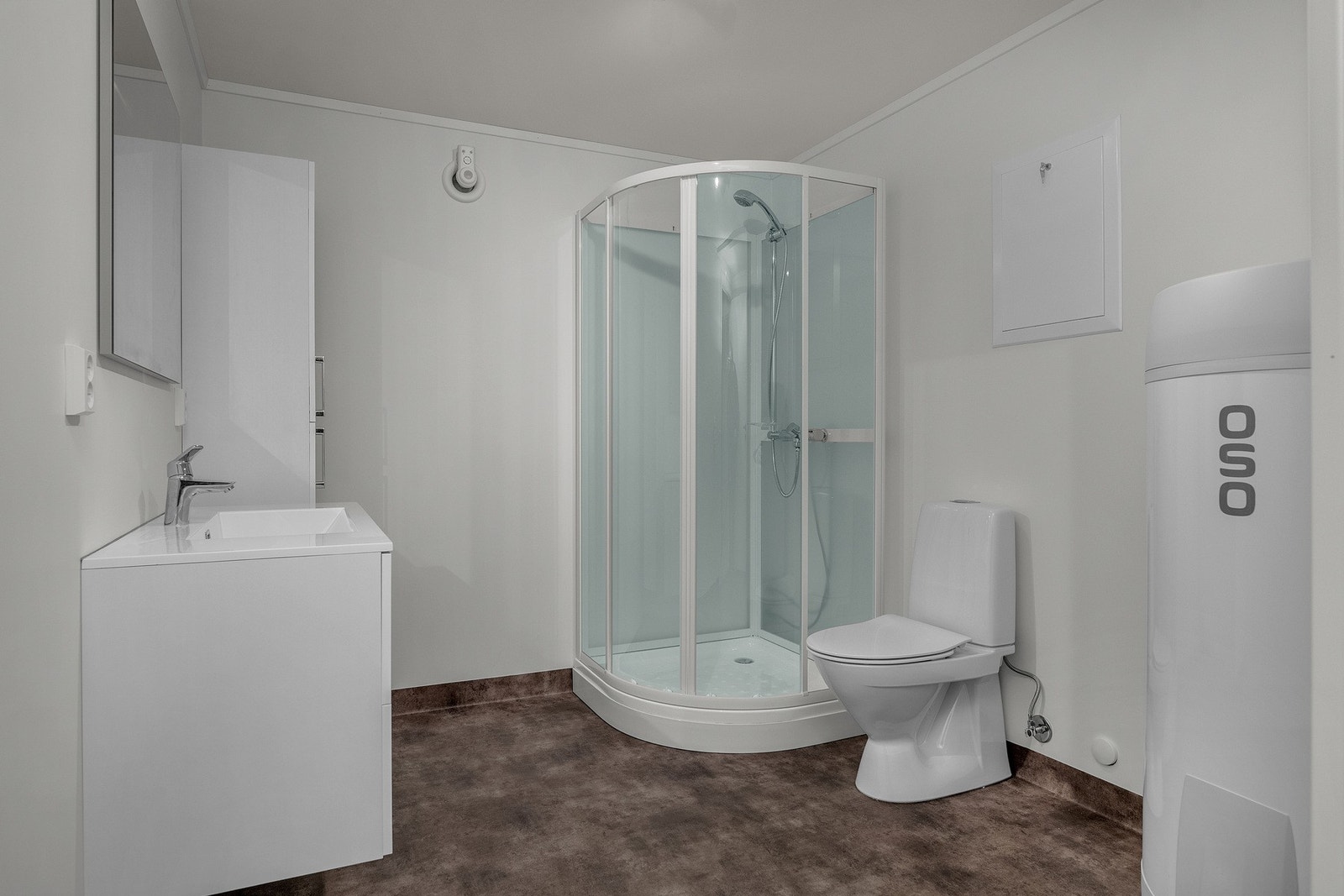 Bad med vegghengt servantinnredning, dusjkabinett, toalett og opplegg for vaskemaskin Galleribilde