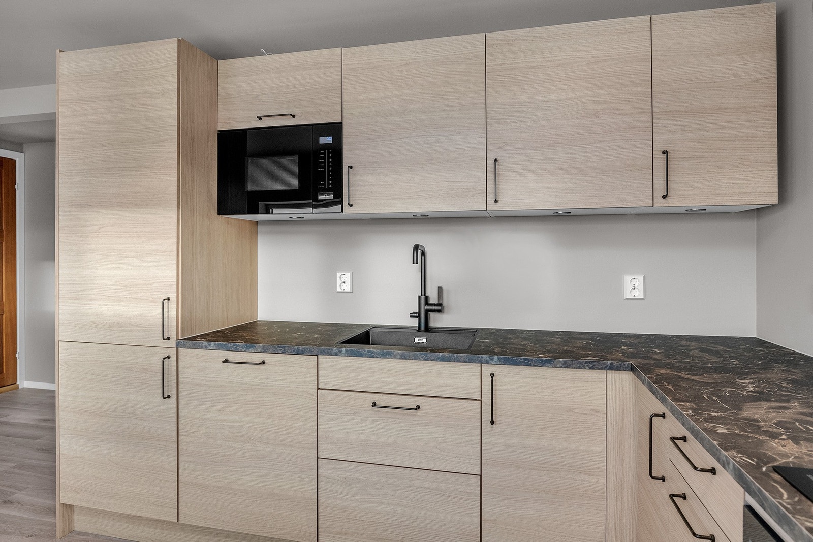 Integrerte hvitevarer består av kjøl-/fryseskap, oppvaskmaskin, induksjonstopp, micro og stekeovn Galleribilde