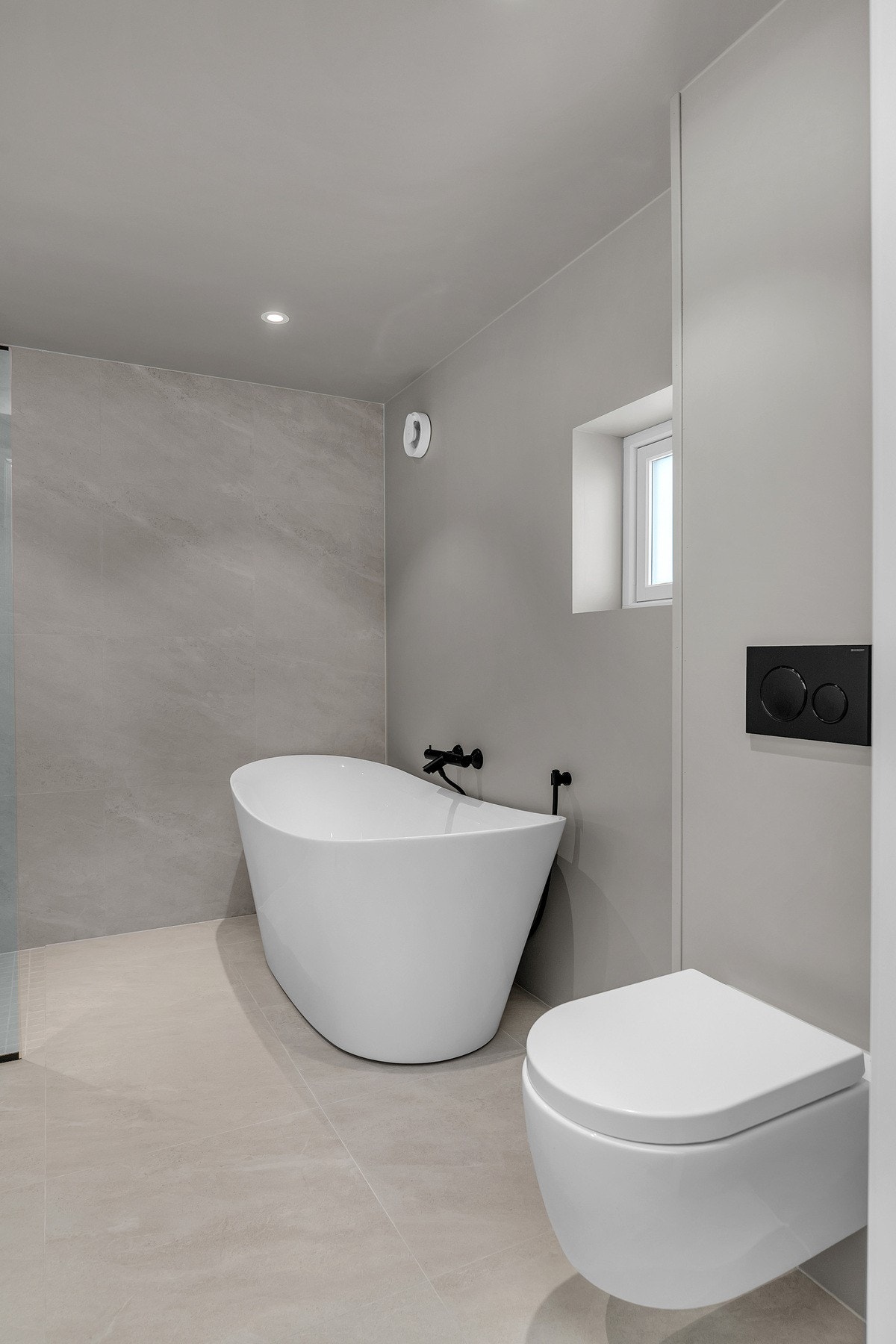 Badet er flislagt med gulvvarme - Utstyrt med vegghengt servantinnredning, dusjhjørne, badekar og toalett Galleribilde