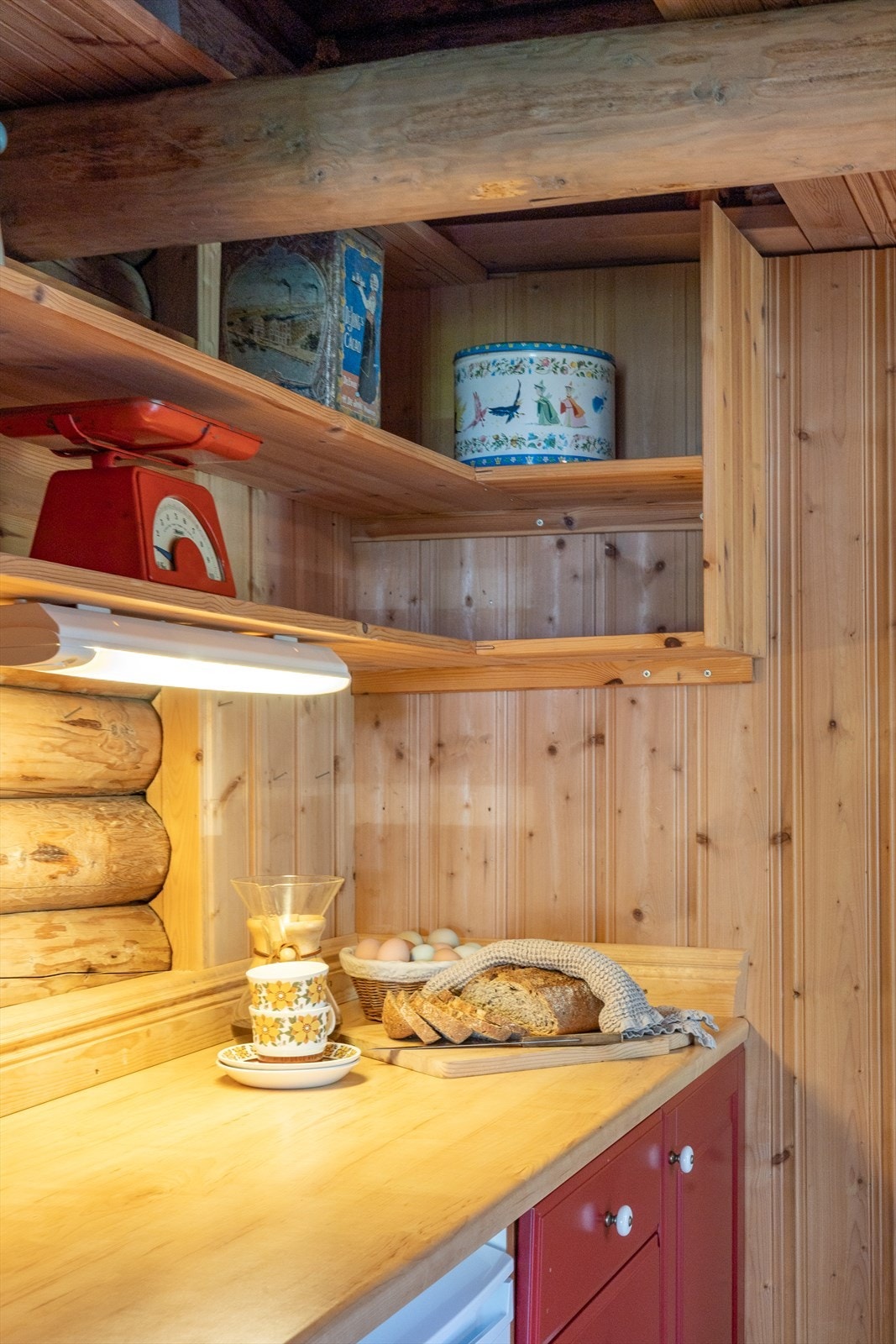 Kjøkkenet har en enkel innredning med malte fronter og benkeplate av laminat. Det er montert et kjøleskap som står under benken. Galleribilde