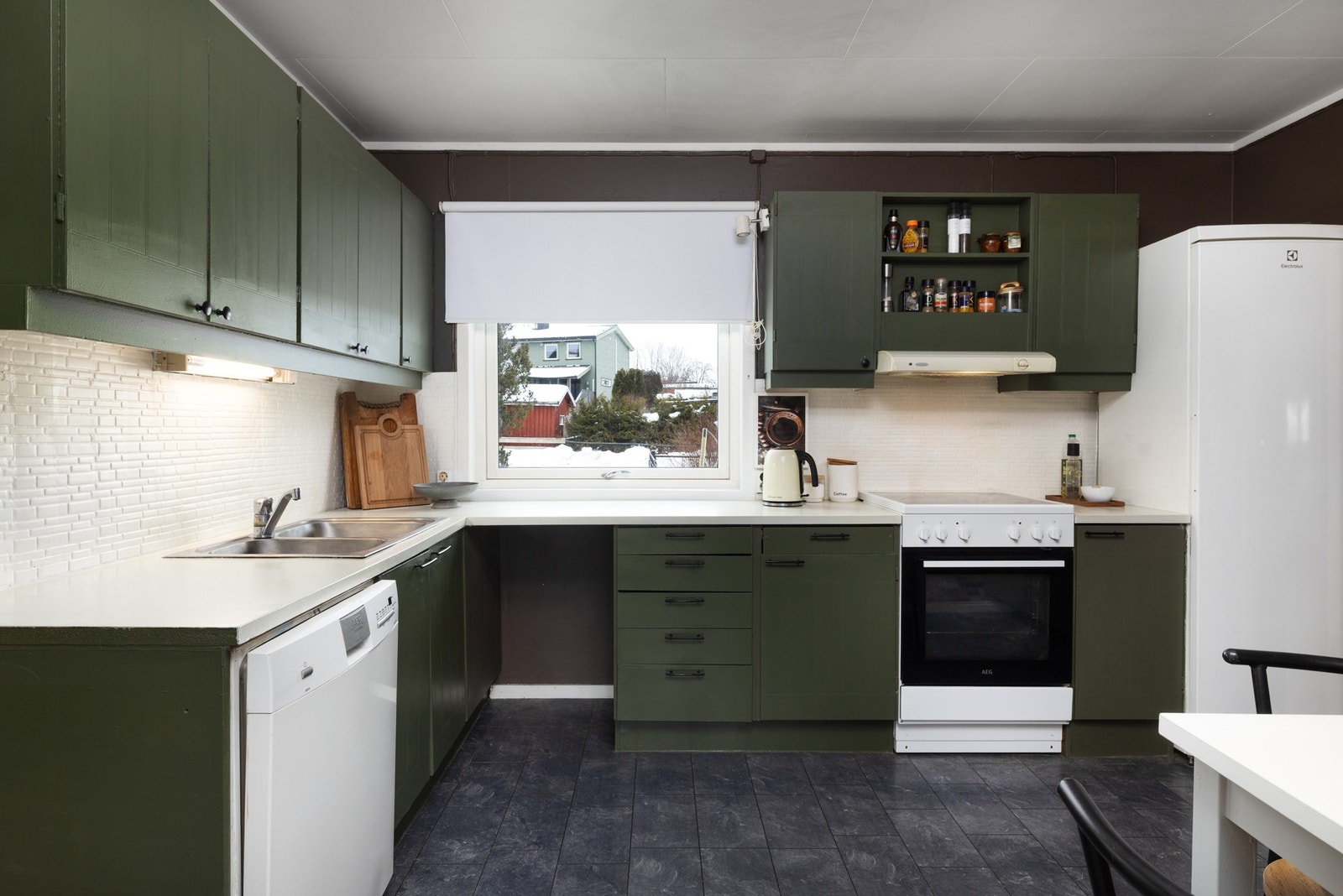 Eldre kjøkken med malt innredning og plass til hvitevarer. Galleribilde