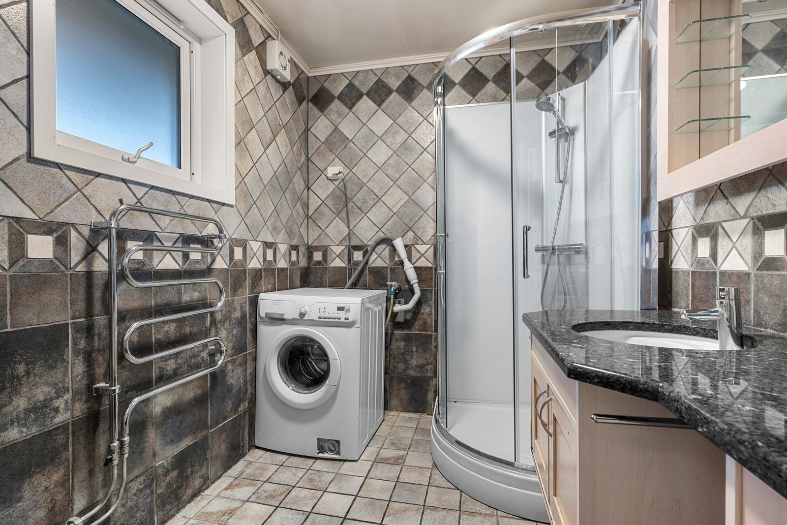 Badet er utstyrt med servantskap, mekanisk avtrekk, opplegg for vaskemaskin og dusjkabinett. Galleribilde