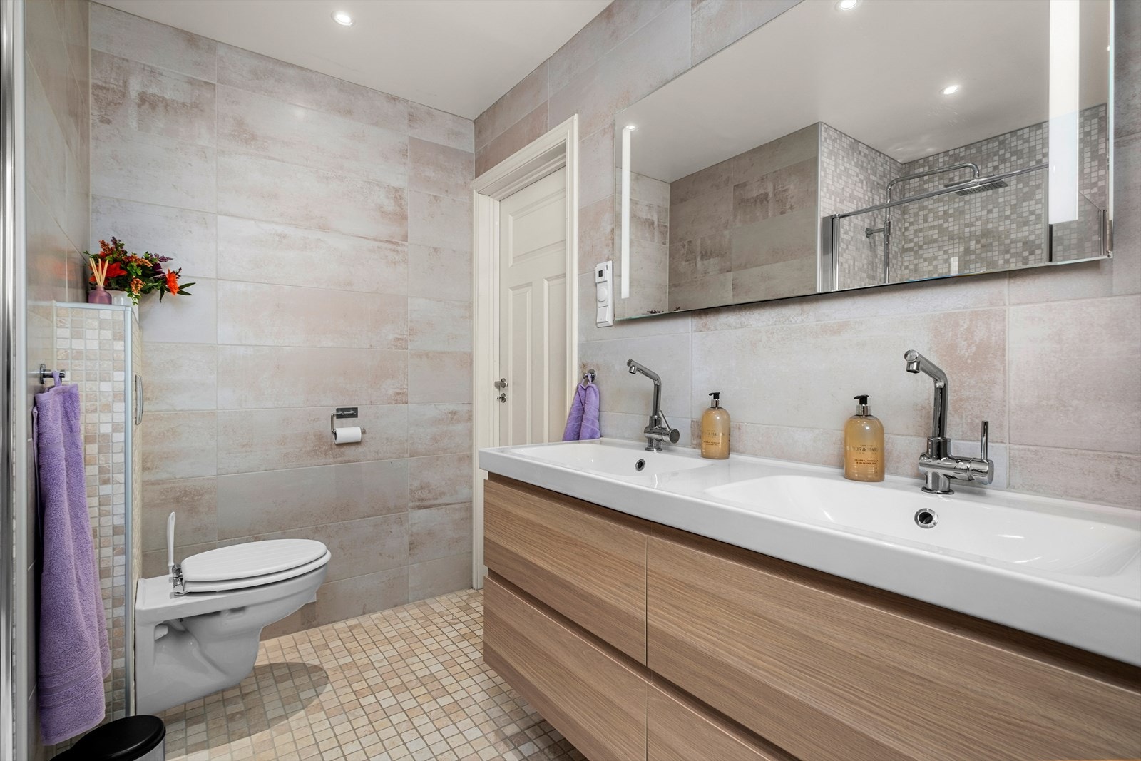 Badet er utstyrt med servantskap, mekanisk avtrekk, opplegg for vaskemaskin, veggmontert WC og innfellbare dusjdører. Galleribilde