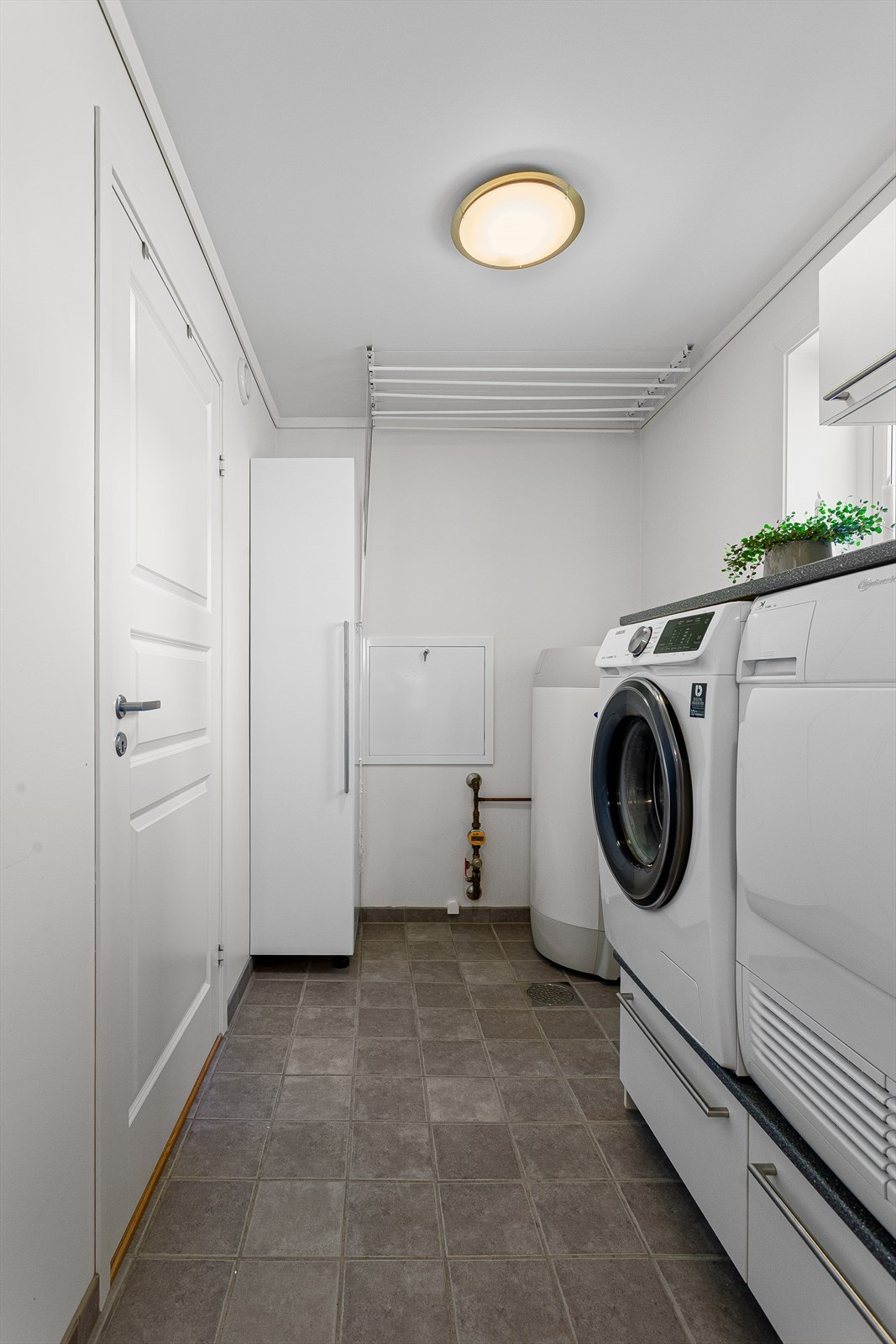 Vaskerom med høyskap, skuffinnredning og gulvvarme Galleribilde