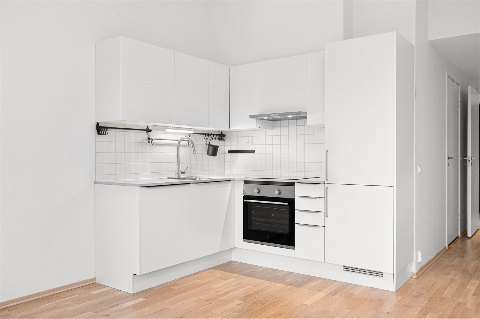 Lyst og fint kjøkken innredet med mekanisk avtrekk over stekesone, integrert stekeovn, platetopp, kombiskap og oppvaskmaskin, Galleribilde