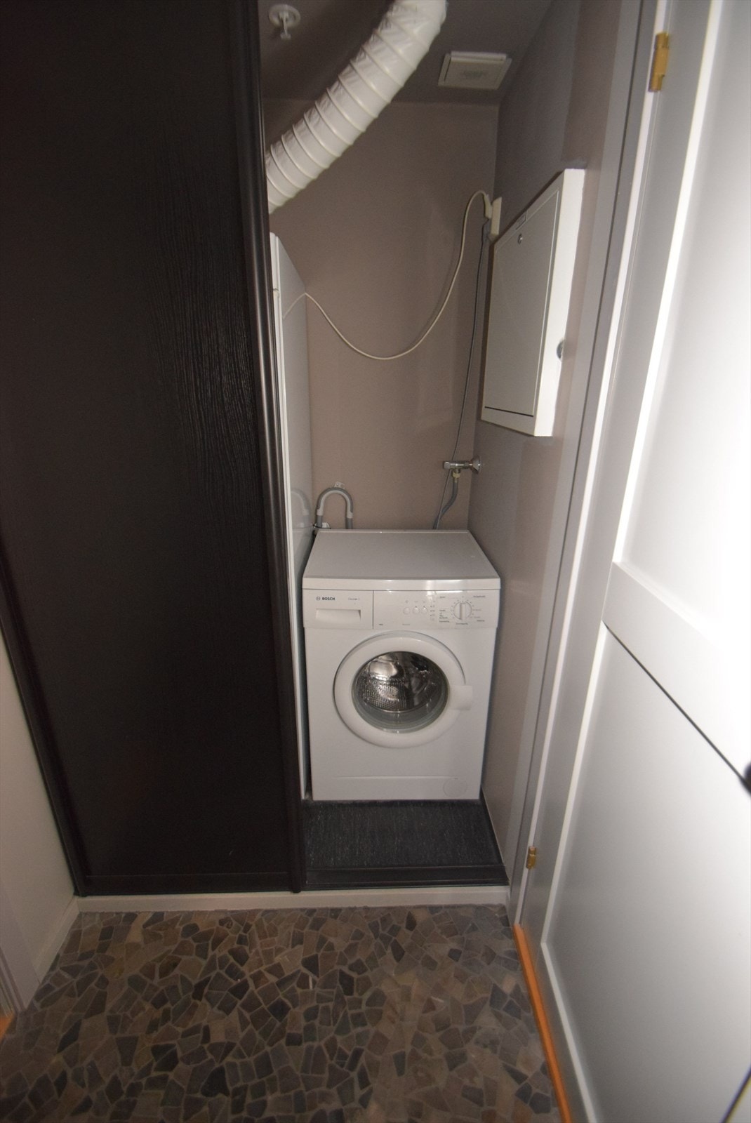 Nisje bak skyvedør i entreen med vaskemaskin og tørkeskap (bilde fra lik naboleilighet) Galleribilde