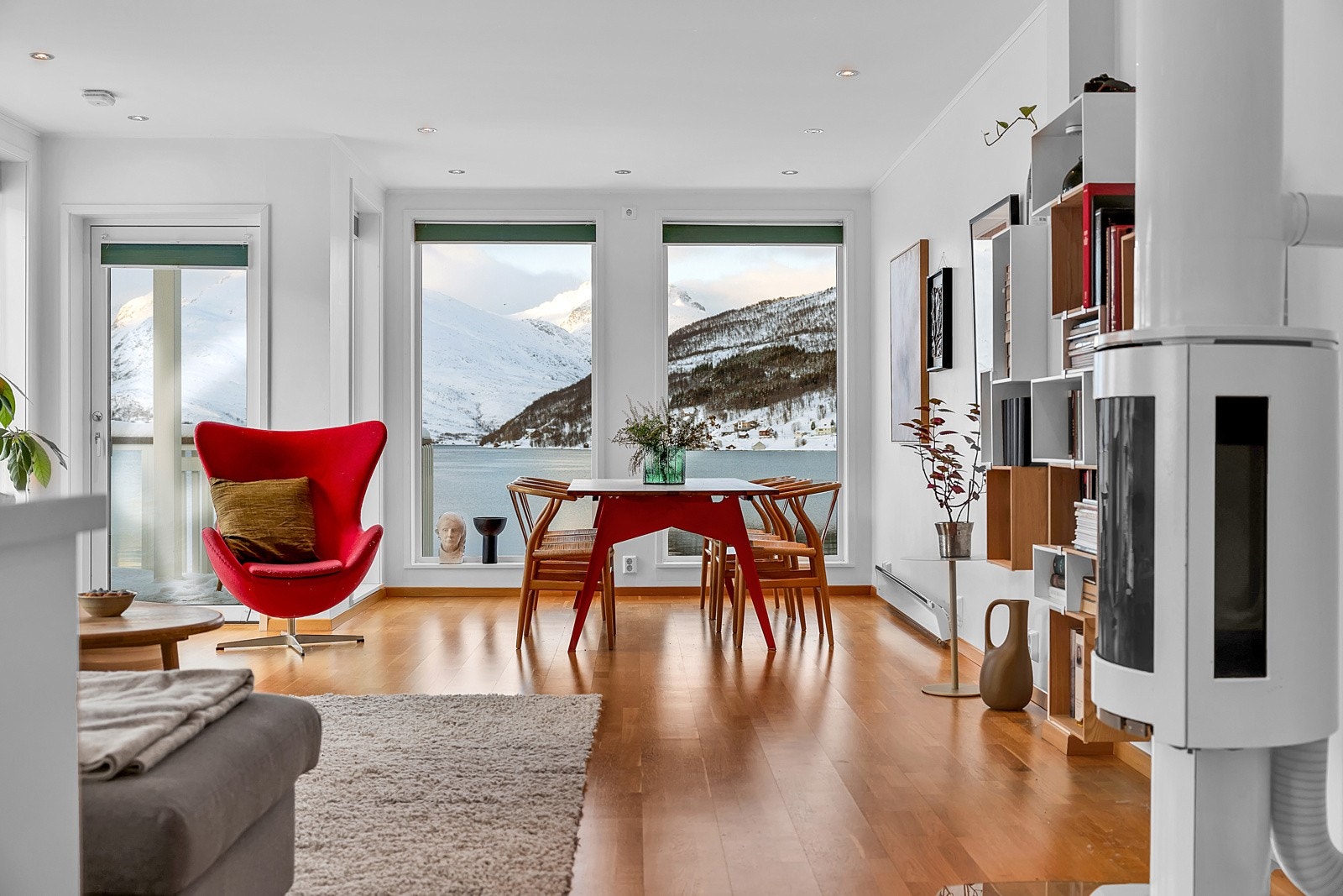 Stue og kjøkken er i åpen løsning hvor der er plassert en moderne og effetiv vedovn i senter av rommet Galleribilde