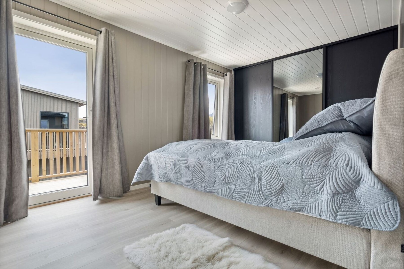 Romslig og stilrent soverom med utgang til egen balkong. Galleribilde