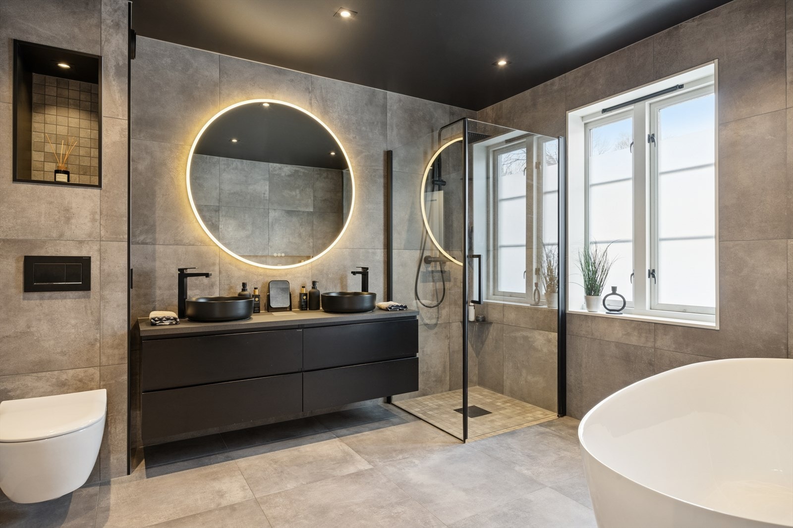 Flott baderom i første etasje med innredning som rommer to servanter, toalett, badekar og dusjhjørne med dusjvegger. Varmekabler i gulv. Galleribilde