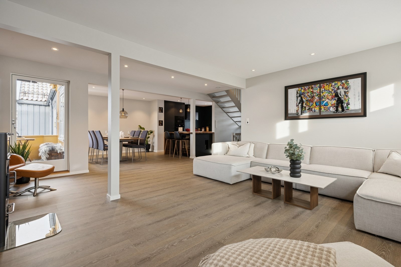 Åpen planløsning mellom stue og kjøkken som gir en luftig og behagelig romfølelse, perfekt for både hverdagsliv og sosiale anledninger. Galleribilde