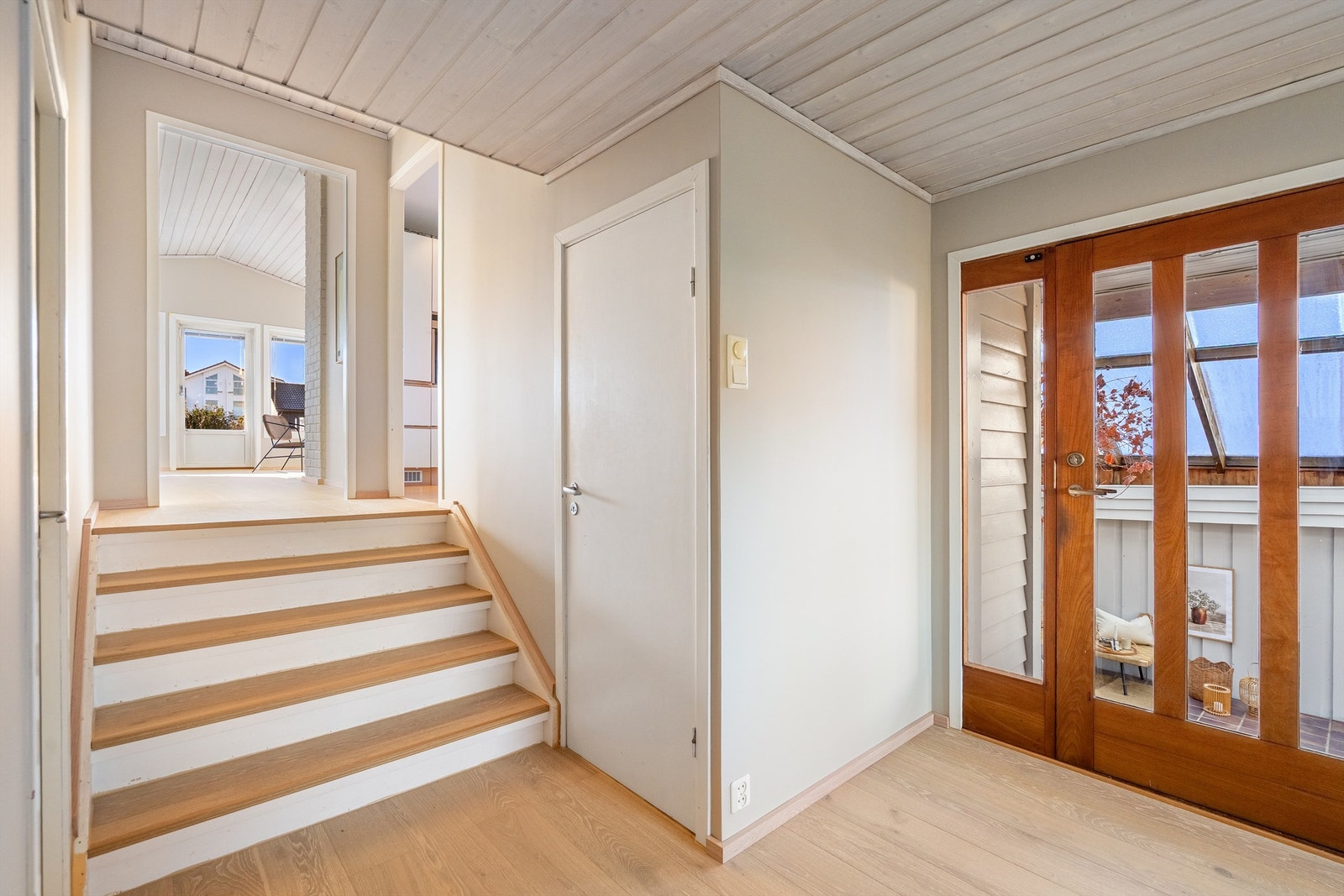 Romslig entré med et halvplan opp til kjøkken og stue. Døren fører ned til kjelleren Galleribilde