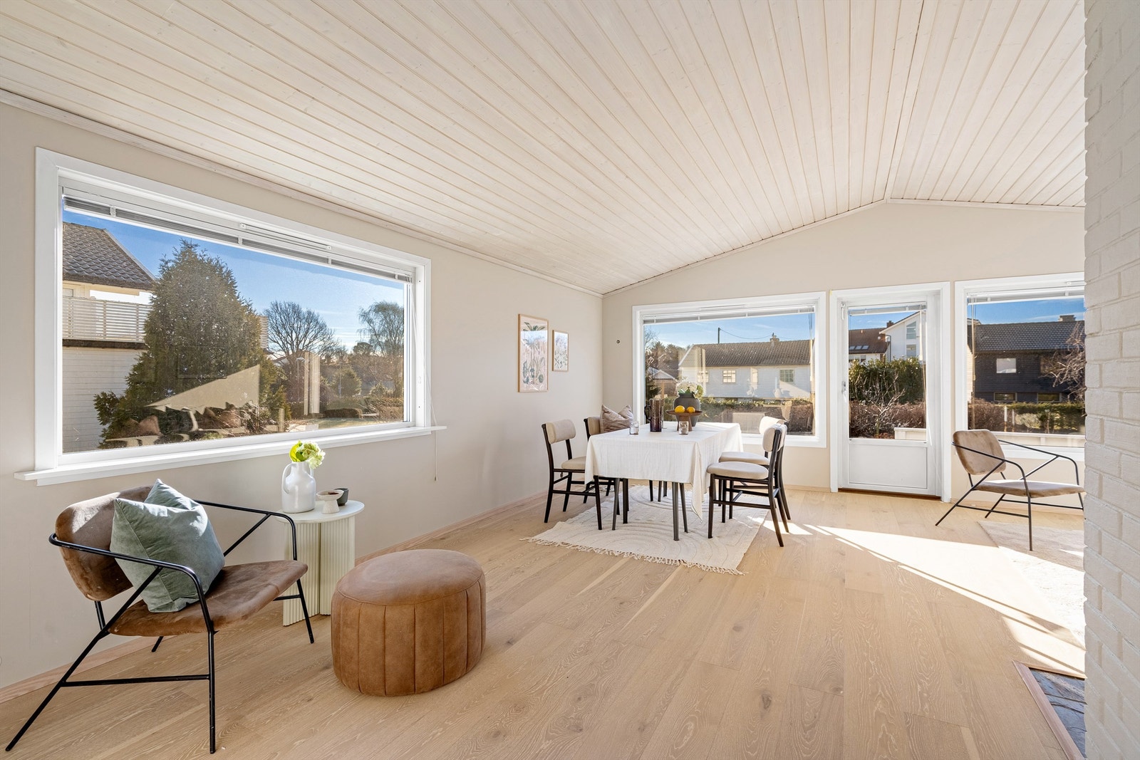 Stuen har stor takhøyde og utgang til solrik terrasse og hage. Langbord er null problem her Galleribilde