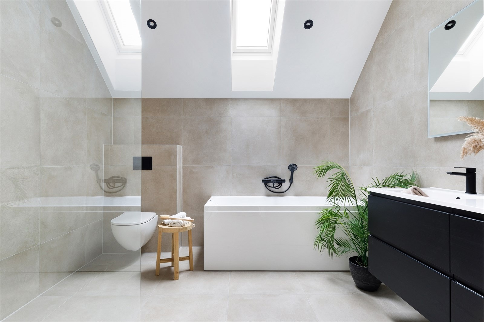 Badet i andre etasje er elegant innredet og har takvinduer som slipper inn naturlig dagslys. Galleribilde