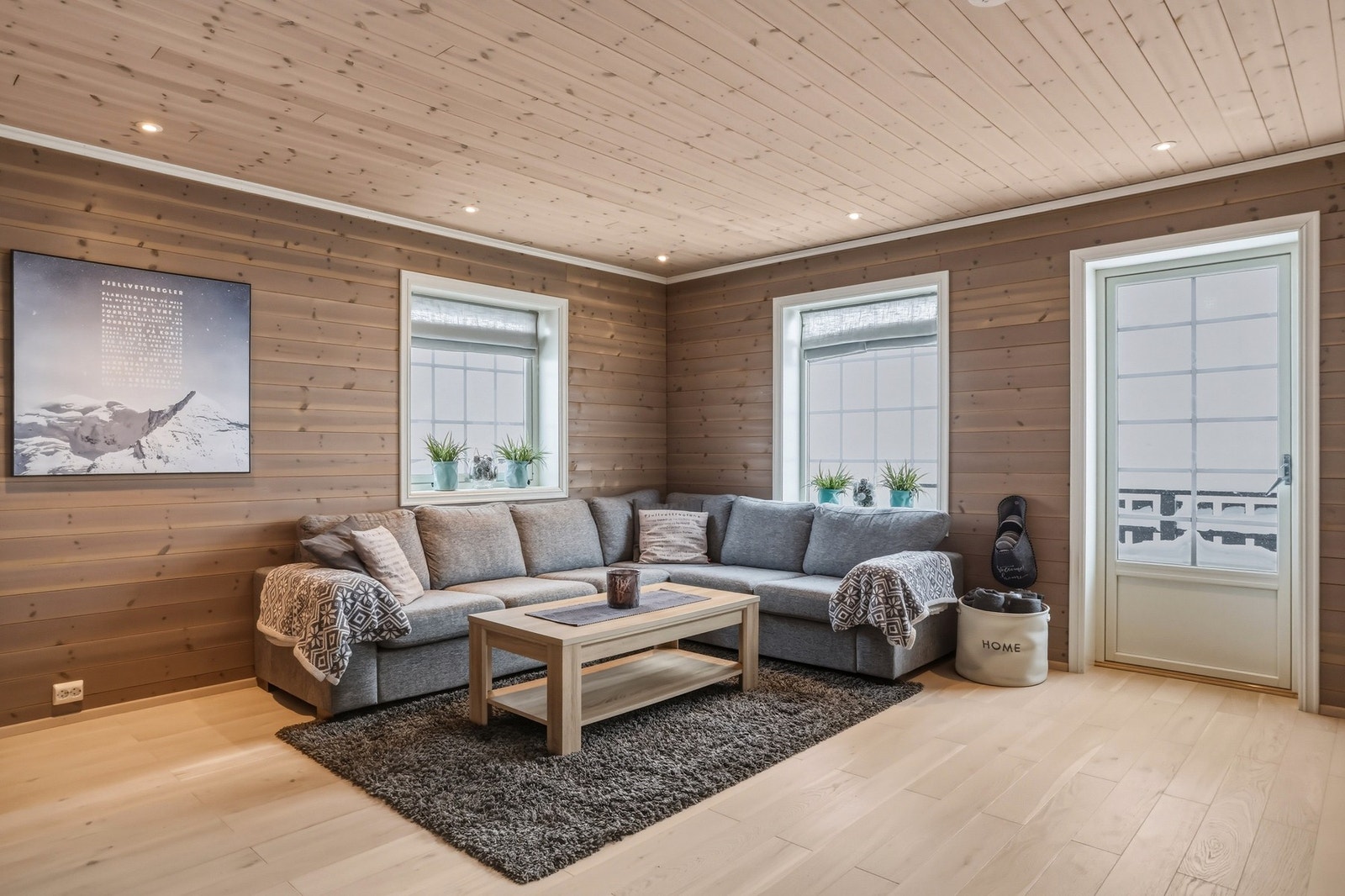 Lun og hyggelig stue med downlights i himling. Beiset panel på vegg og parkett på gulv Galleribilde