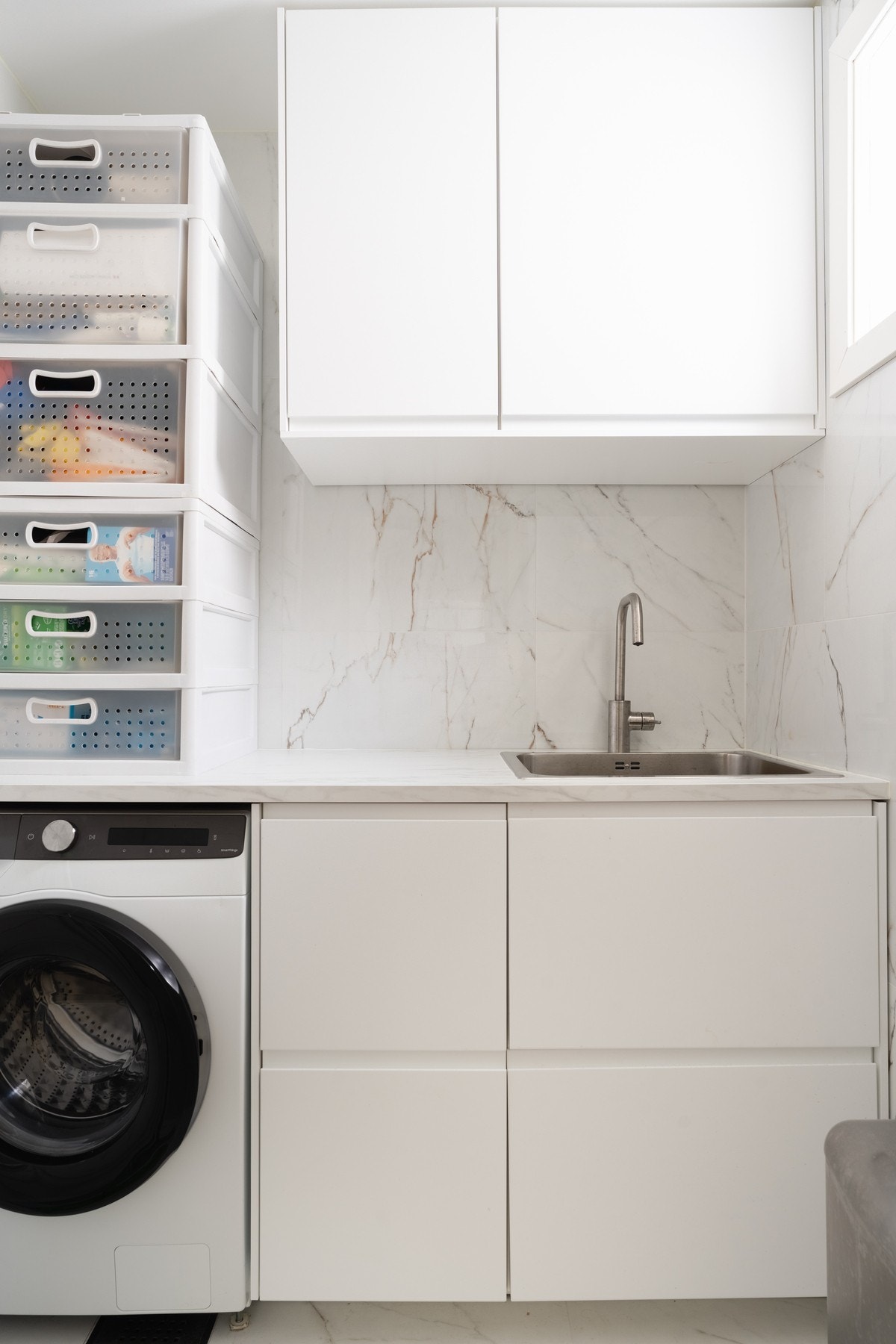 Vaskerommet ble også pusset opp i 2024 og har de samme, delikate flisene som på bad. Her er det utslagsvask, samt opplegg for vaskemaskin og tørketrommel. Galleribilde