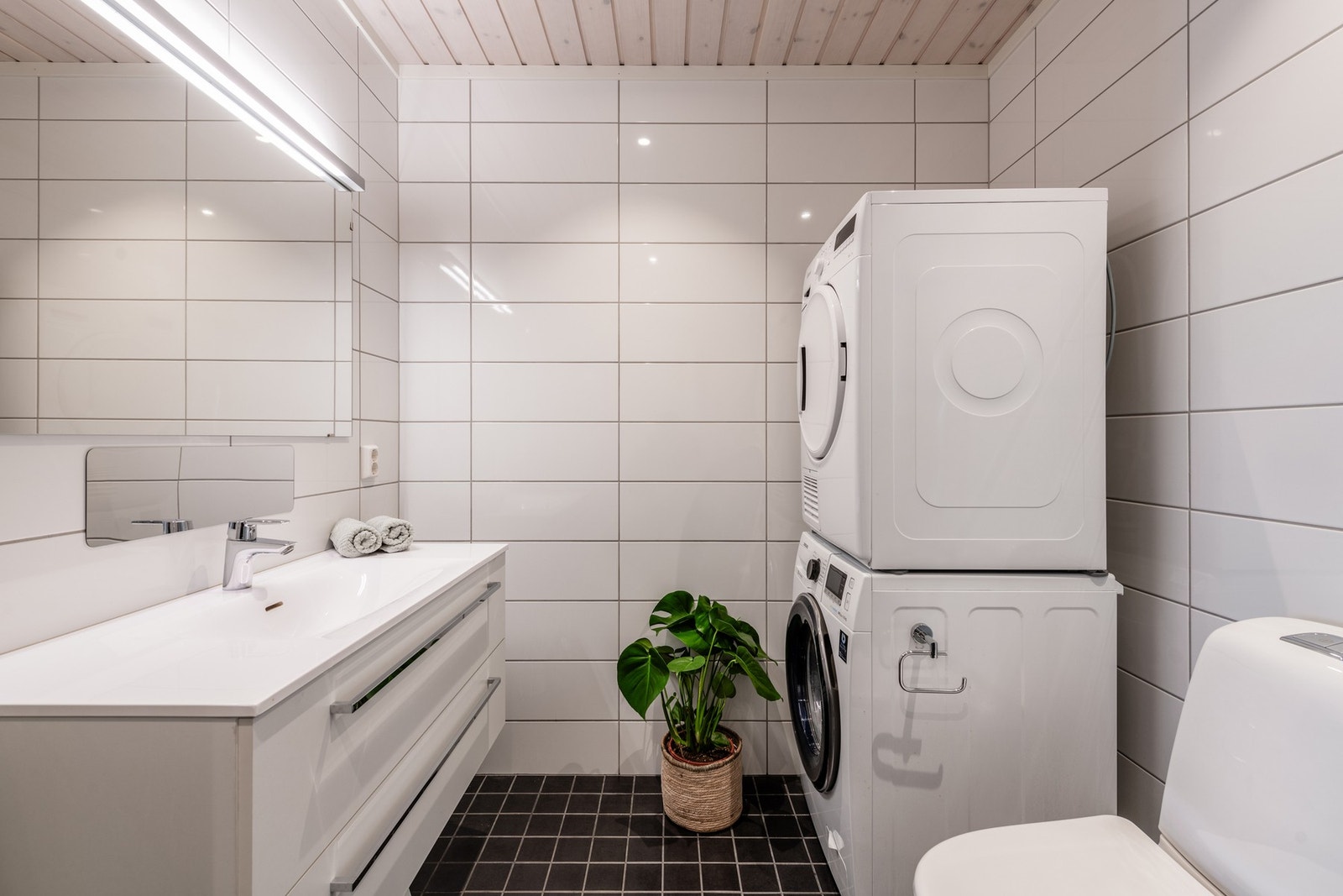 Delikat, flislagt bad med opplegg for vaskemaskin. Galleribilde