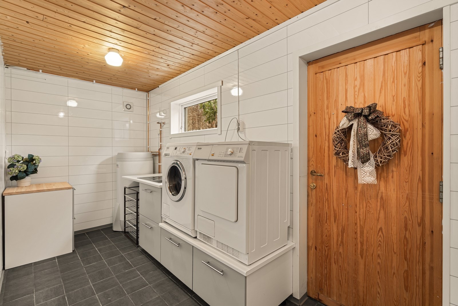 Praktisk vaskerom med opplegg for vaskemaskin og tørketrommel. Her er det også egen biinngang Galleribilde