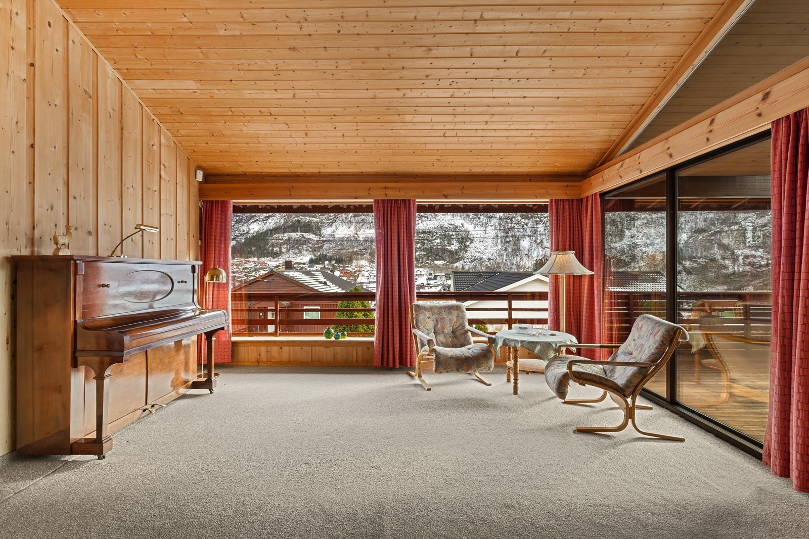 Stuen har store vindusflater som gir rommet rikelig med naturlig lys Galleribilde