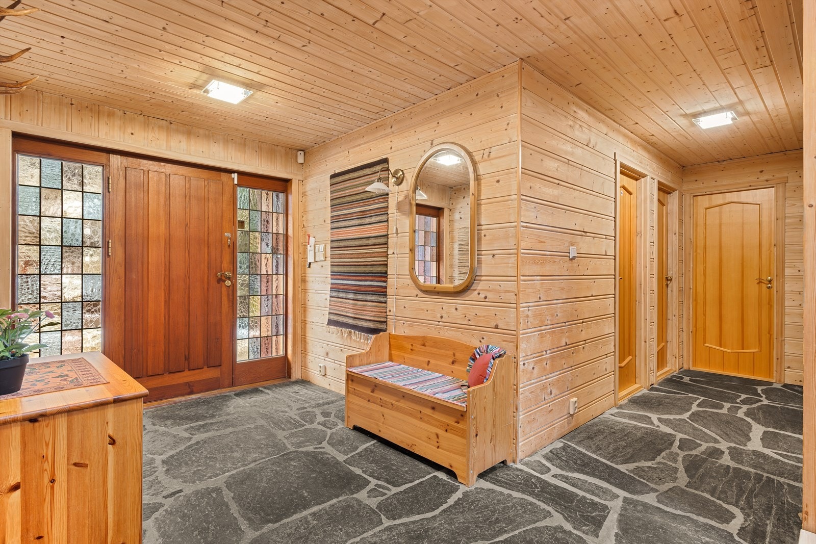 Inngangspartiet er belagt med flott skiferstein, og veggene har trepanel som gir et lunt og solid preg Galleribilde