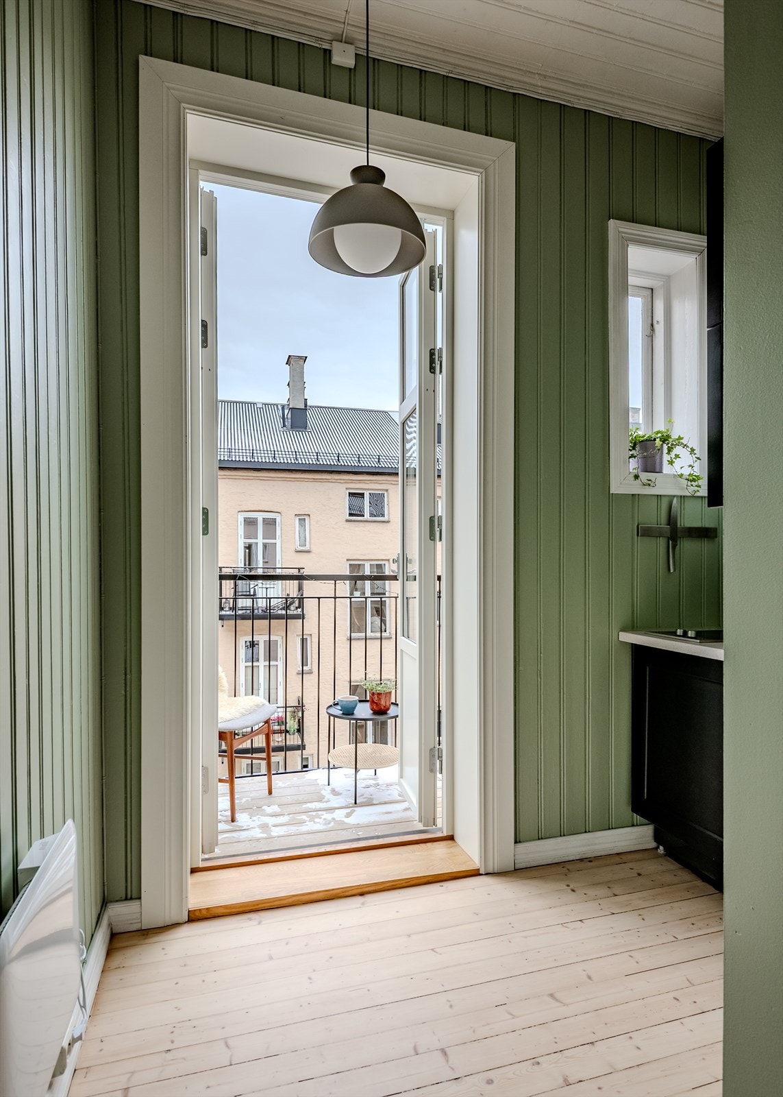 På motsatt side av leiligheten, inn mot byggets rolige bakgård finner vi leilighetens kjøkken, med adkomst til balkongen. Galleribilde