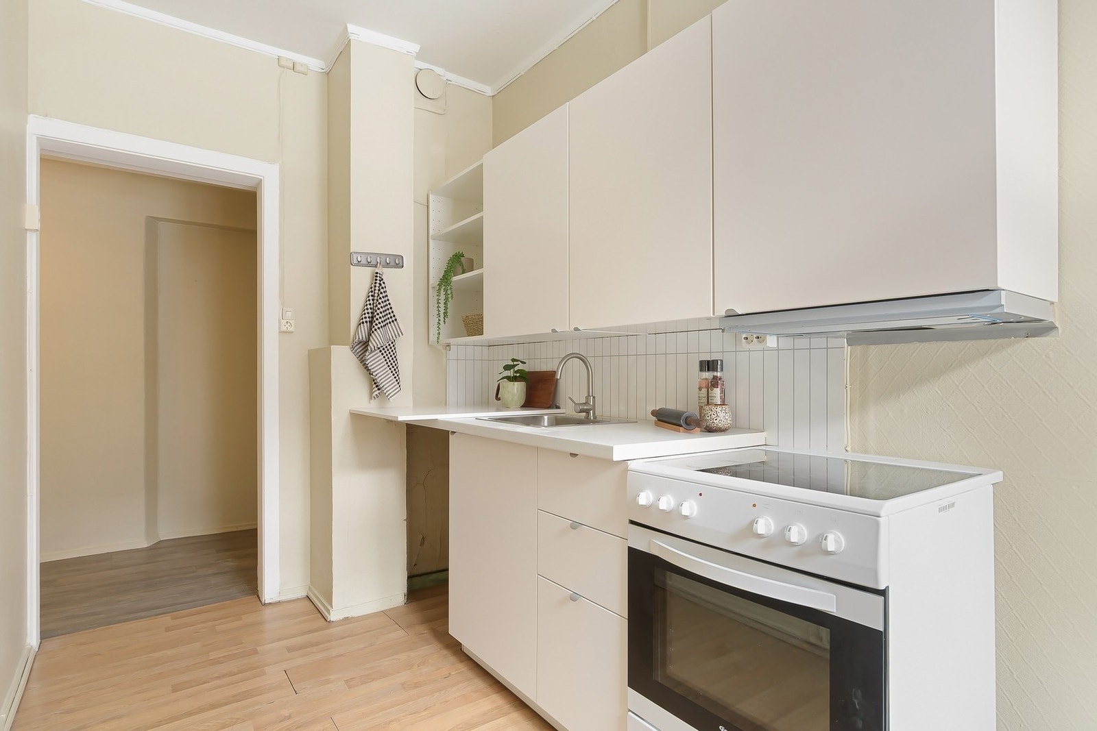 Separat kjøkken med opplegg for vaskemaskin eller oppvaskmaskin i tomt skap. Galleribilde