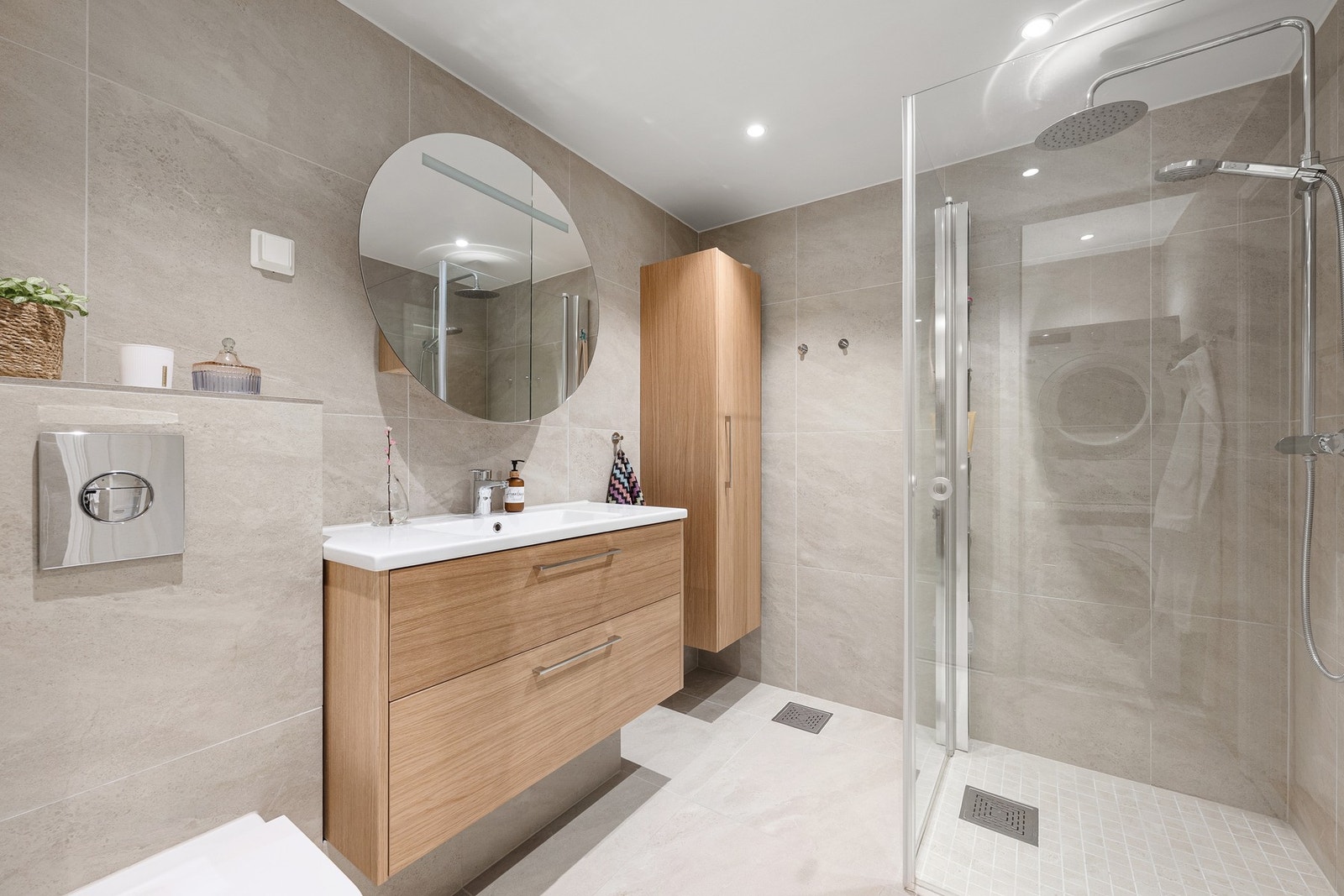 Delikat og helfliset bad fra 2024 med store fliser, innfelt belysning og gjennomført materialvalg. Rommet har romslig dusjsone med glassvegger, regndusj og hånddusj, samt stilren innredning med god oppbevaringsplass. Galleribilde