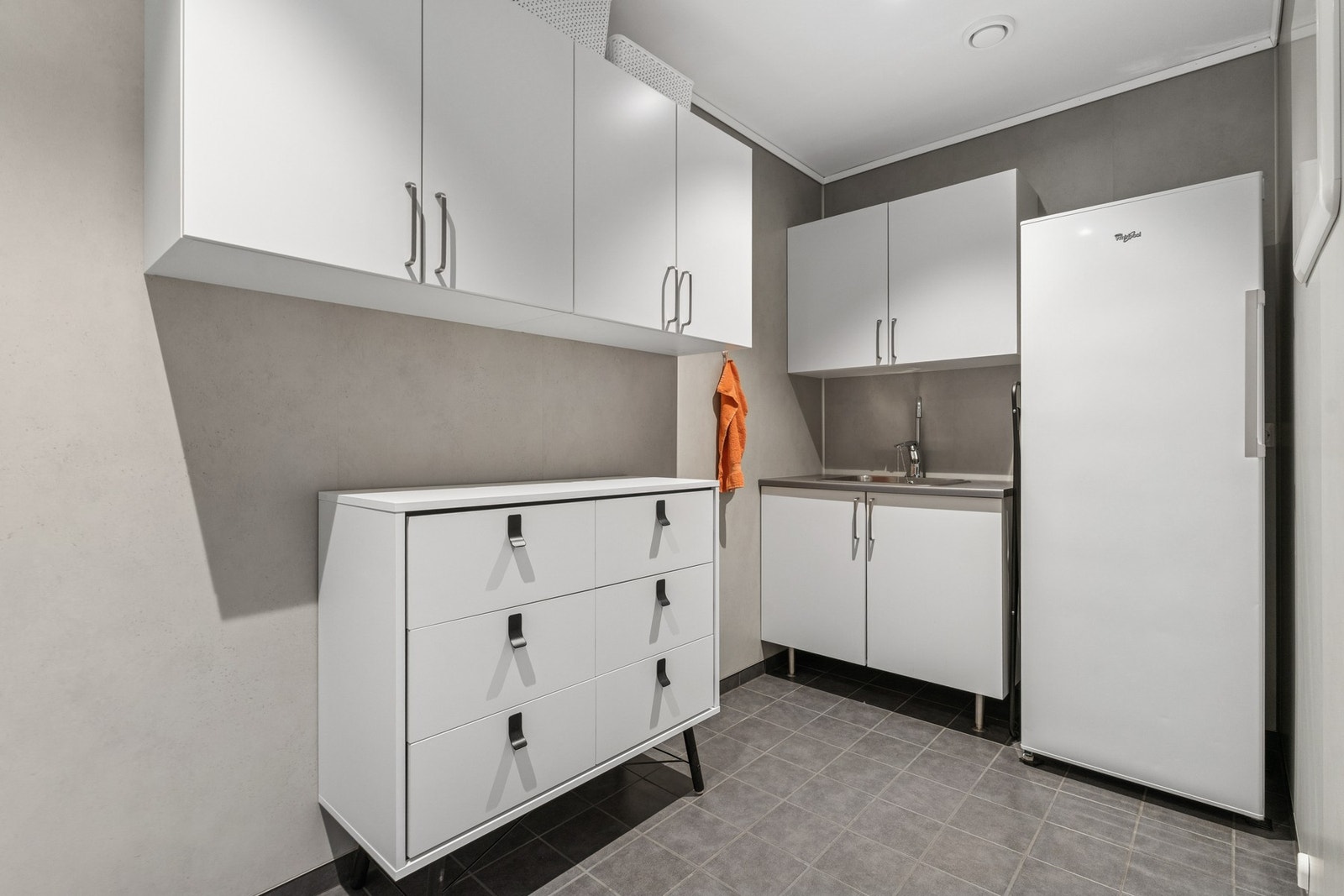 Praktisk vaskerom med innredning, vask og opplegg til vaskemaskin og tørketrommel. Galleribilde