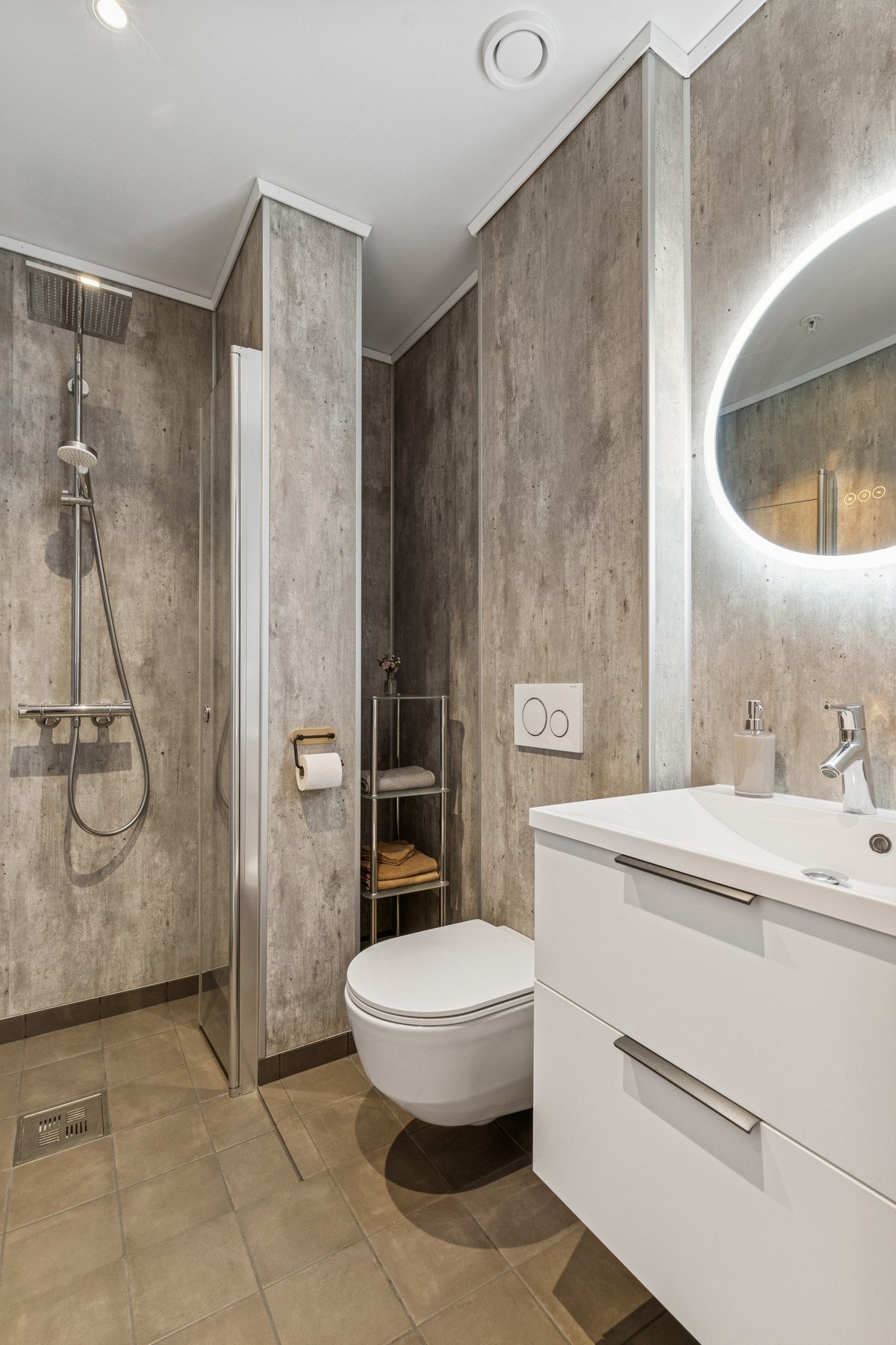 Gjestebad med veggheng toalett, dusjnisje og baderomsinnredning. Galleribilde