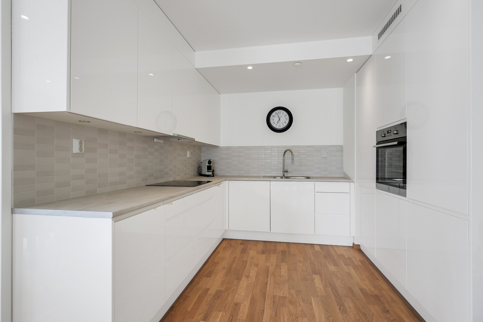 Lys innredning med slette fronter fra bygge året med mye skap og benkeplass. Galleribilde