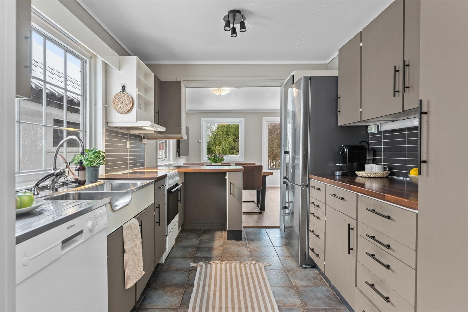 Kjøkkenet har en innredning med glatte fronter og benkeplate i laminat Galleribilde