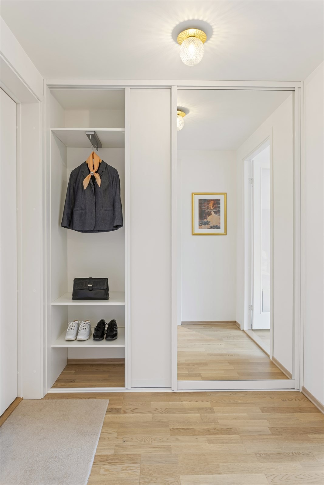 Romslig og praktisk skyvedørsgarderobe levert av Garderobeeksperten i entréen. Galleribilde