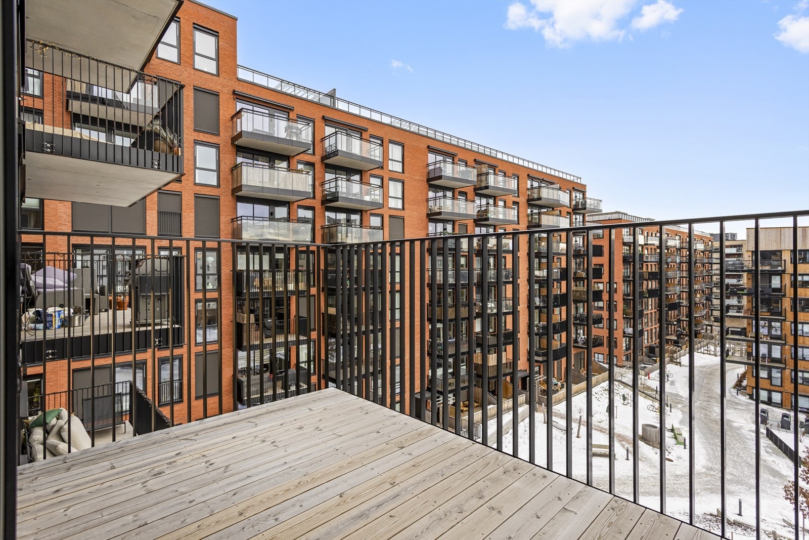 Balkongen er romslig, har spaltegulv av tre og lysarmatur på vegg. Galleribilde