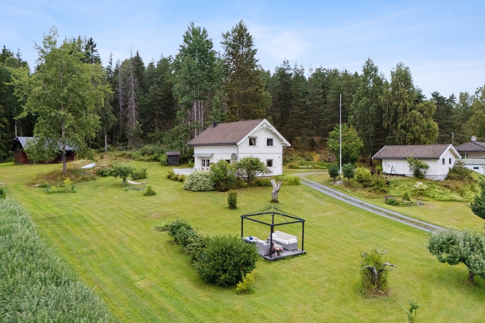 Den store tomten er delvis opparbeidet med plen og beplantning, og har også en flott naturtomt. Galleribilde