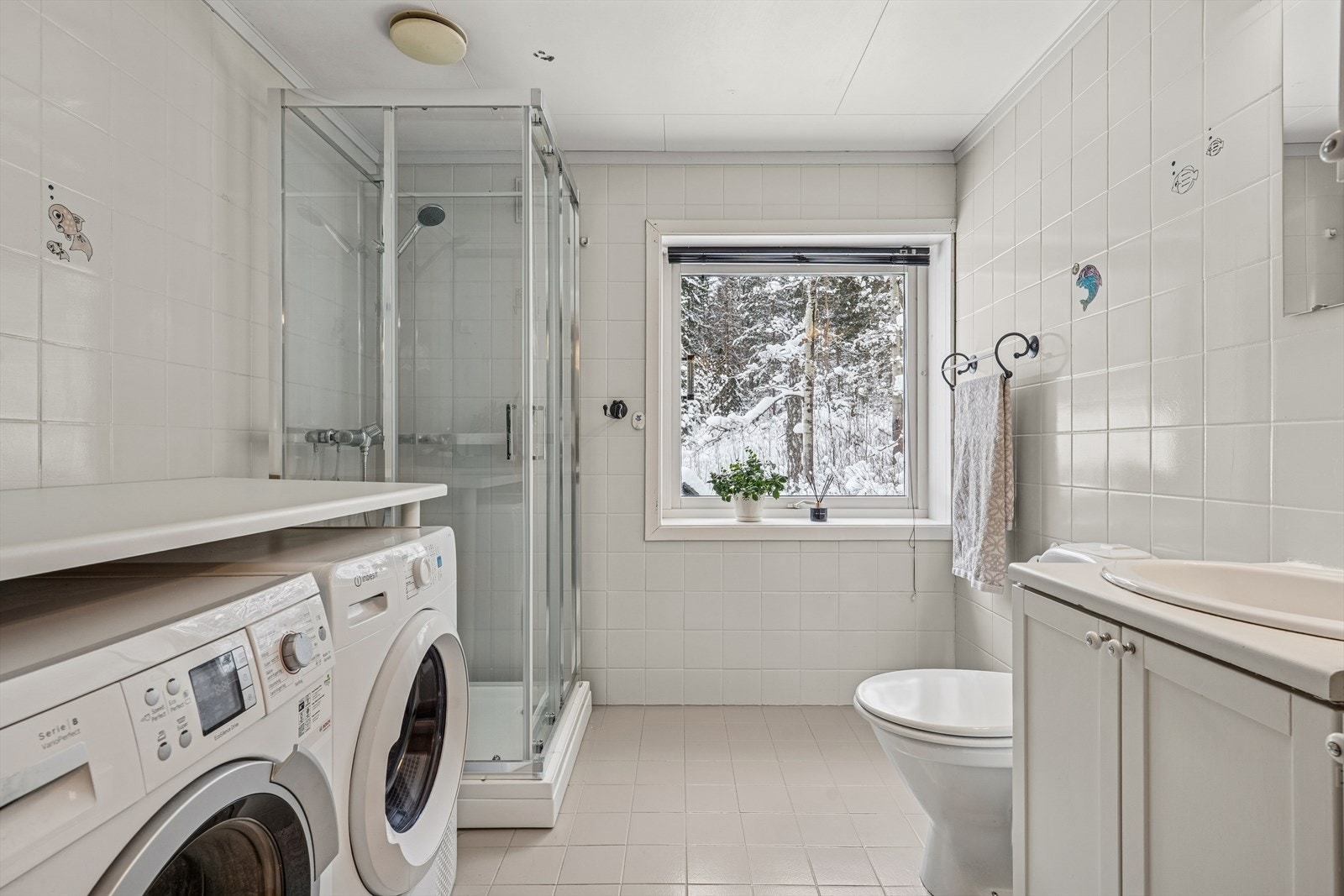 Rommet har malte fliser på gulv og vegger, og er utstyrt med dusjkabinett. Galleribilde