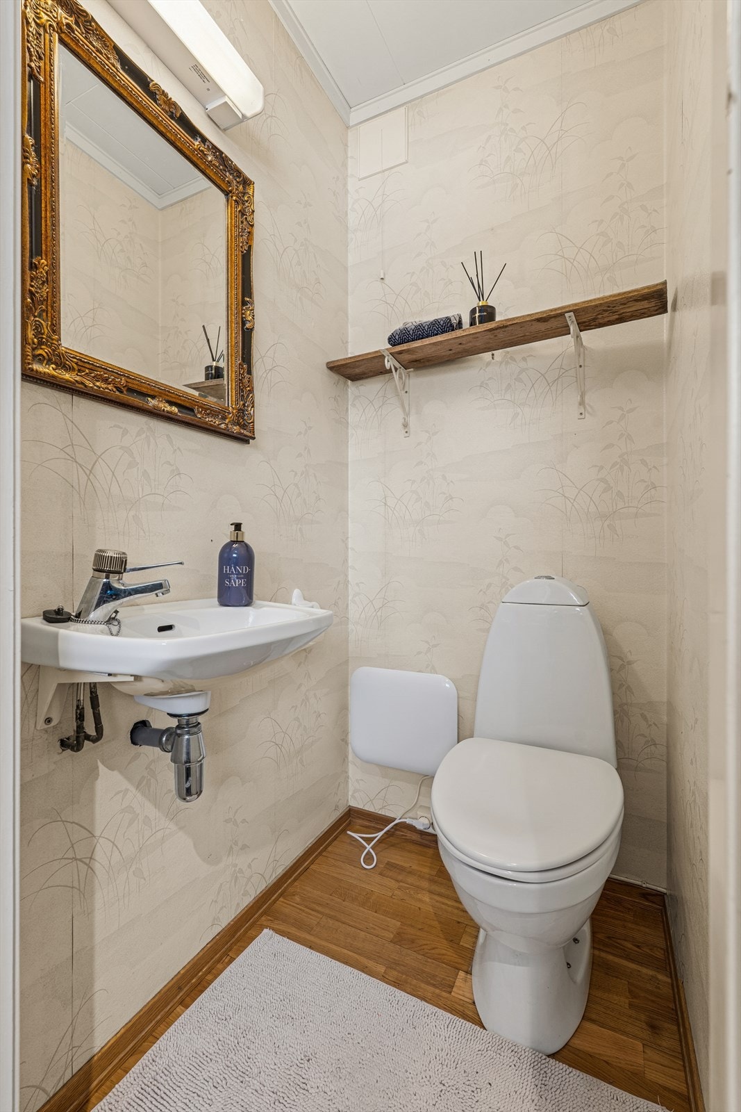 Praktisk toalettrom i første etasje, innredet med servant og toalett. Galleribilde