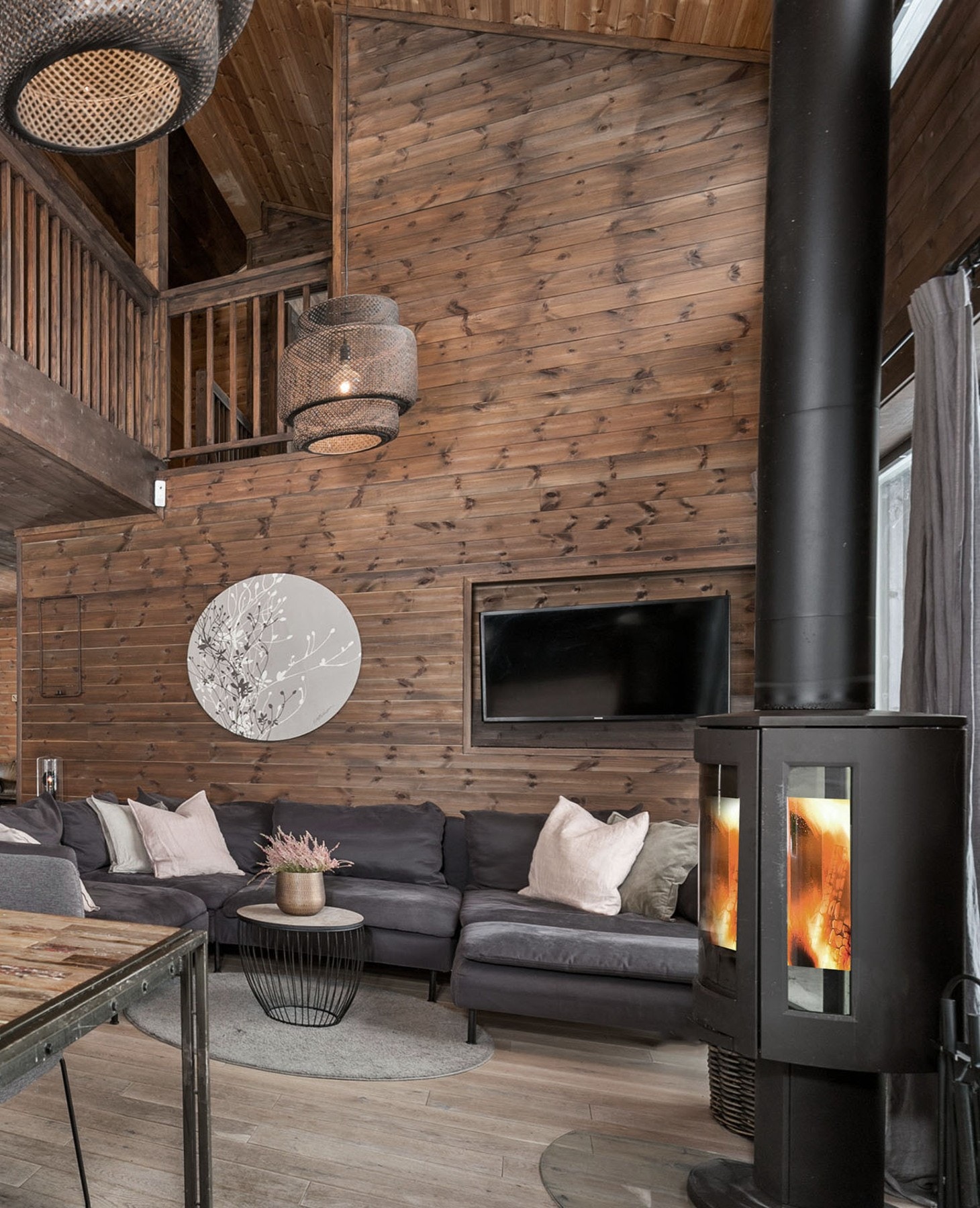 Moderne peisovn mellom vinduene skaper varme og hygge. God plass til sofa med tilhørende møblement. Galleribilde