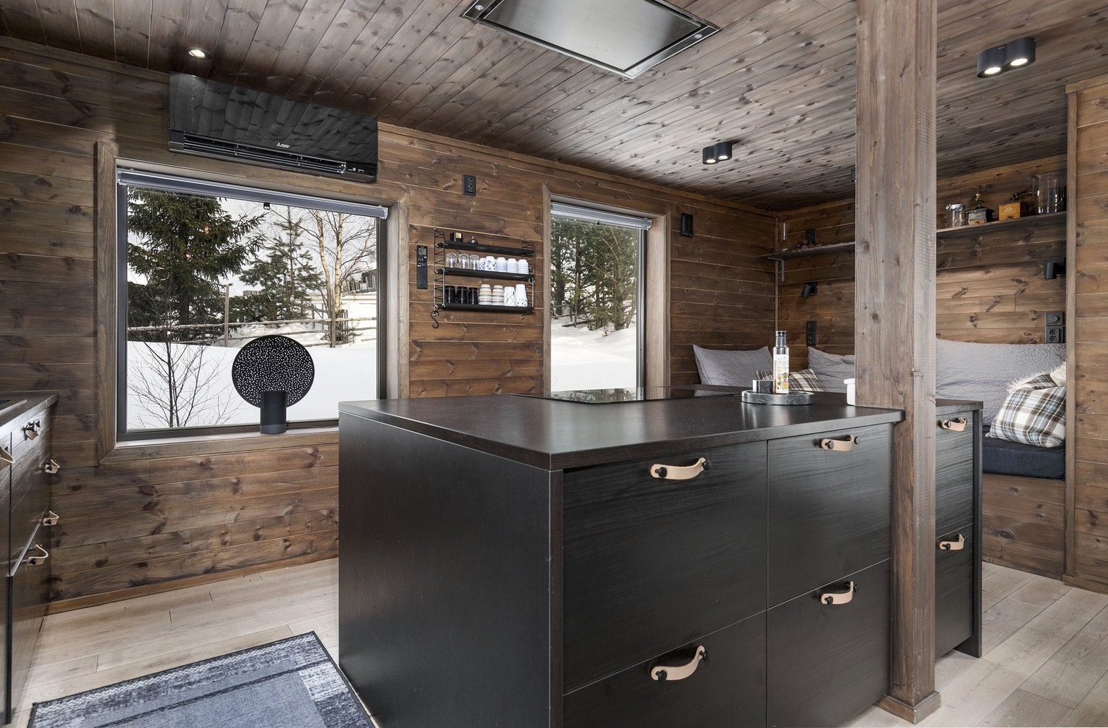 Stilrent kjøkken fra Ikea i åpen løsning. Plassbygget daybed sees i bakgrunnen. Galleribilde