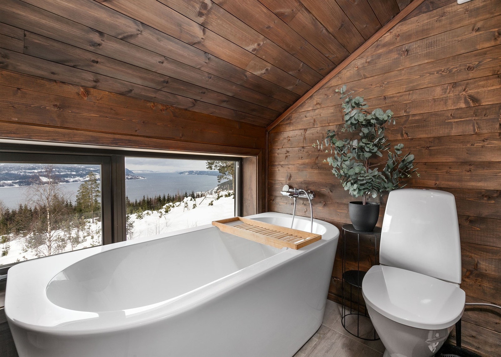 Videre har badet et frittstående ovalt badekar plassert foran vinduene som gir panoramautsikt over Mjøsa - en avslappende zen-sone . Galleribilde