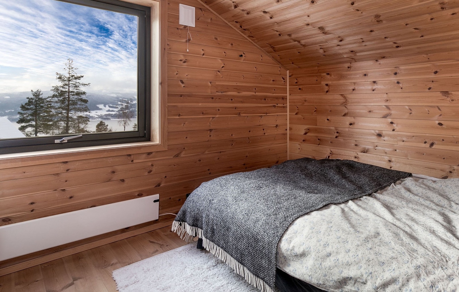 Soverom 2 har beiset panel på veggflater, heltre gulv og sjarmerende skråtak. Galleribilde