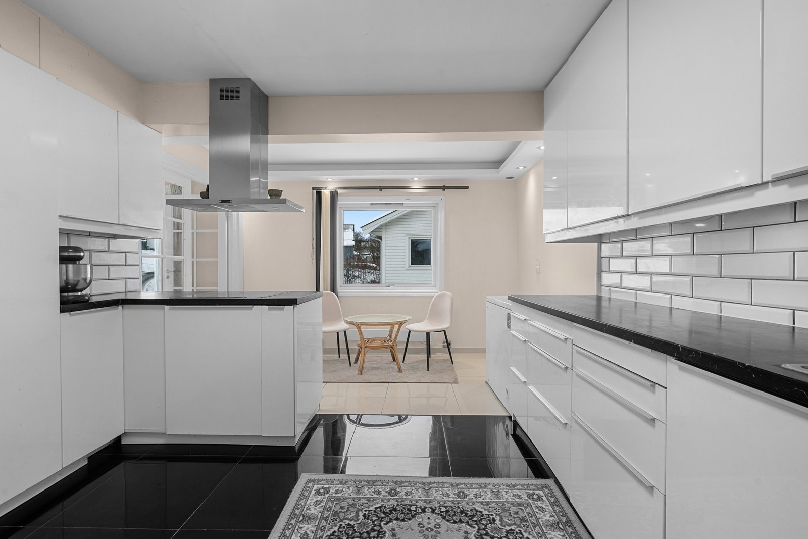 Integrerte hvitevarer og downlights i taket gir et moderne og funksjonelt kjøkkenmiljø. Galleribilde