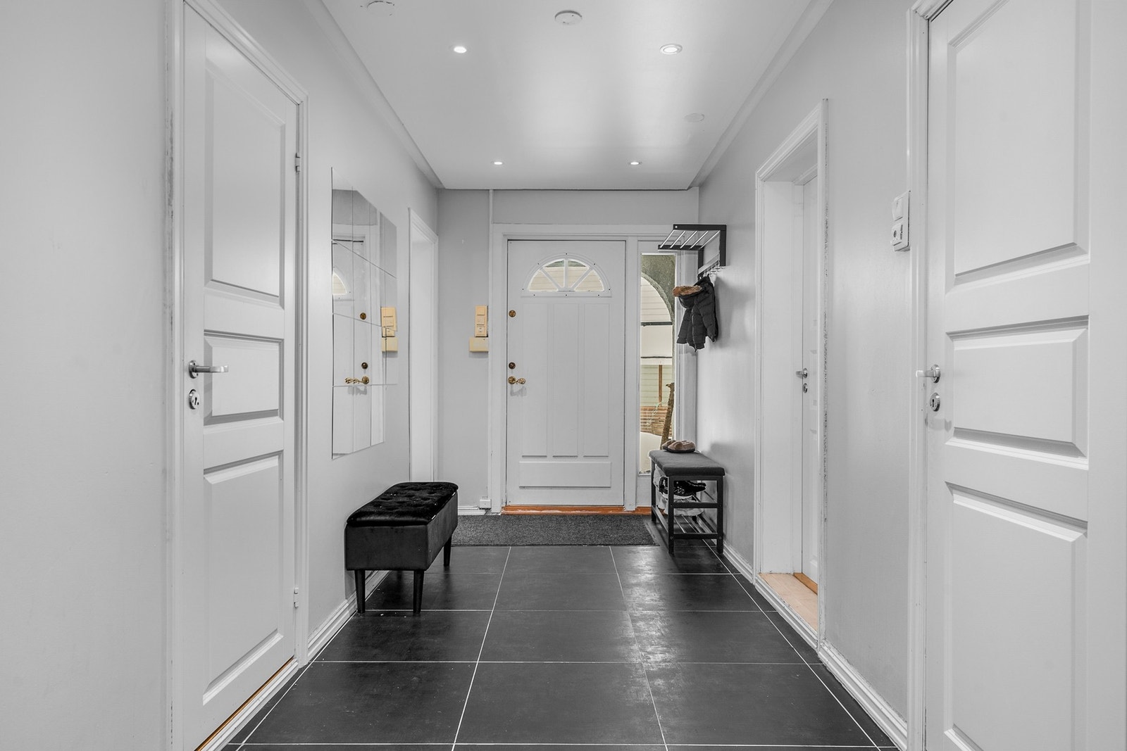 Flislagt gulv og downlights gir en moderne entré med enkel tilgang til rommene. Galleribilde