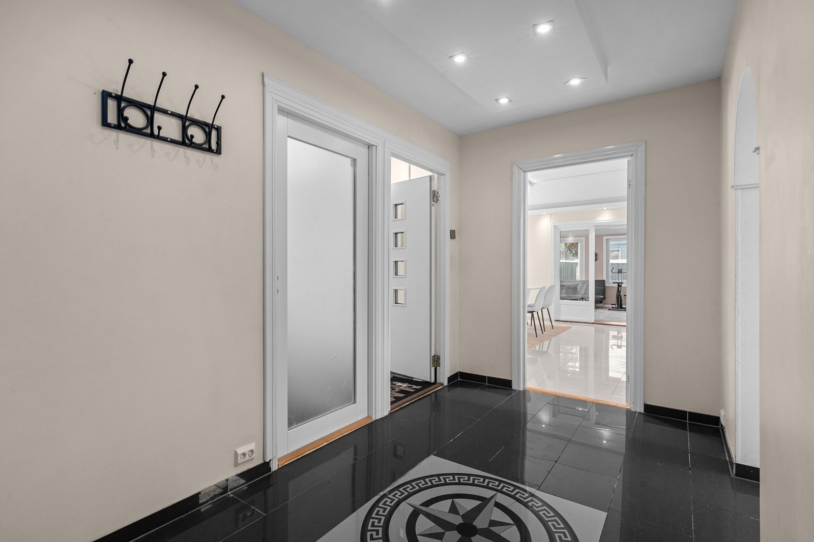 Flislagt gulv med innfelte downlights gir et lyst og elegant inngangsparti. Galleribilde
