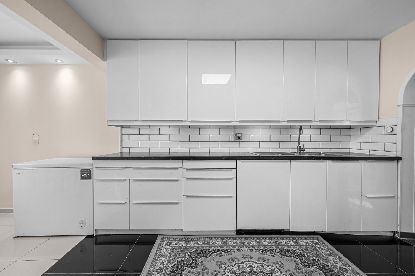 Fliser på veggen over benken gir et praktisk arbeidsområde med lett tilgang til oppbevaringsplass. Galleribilde