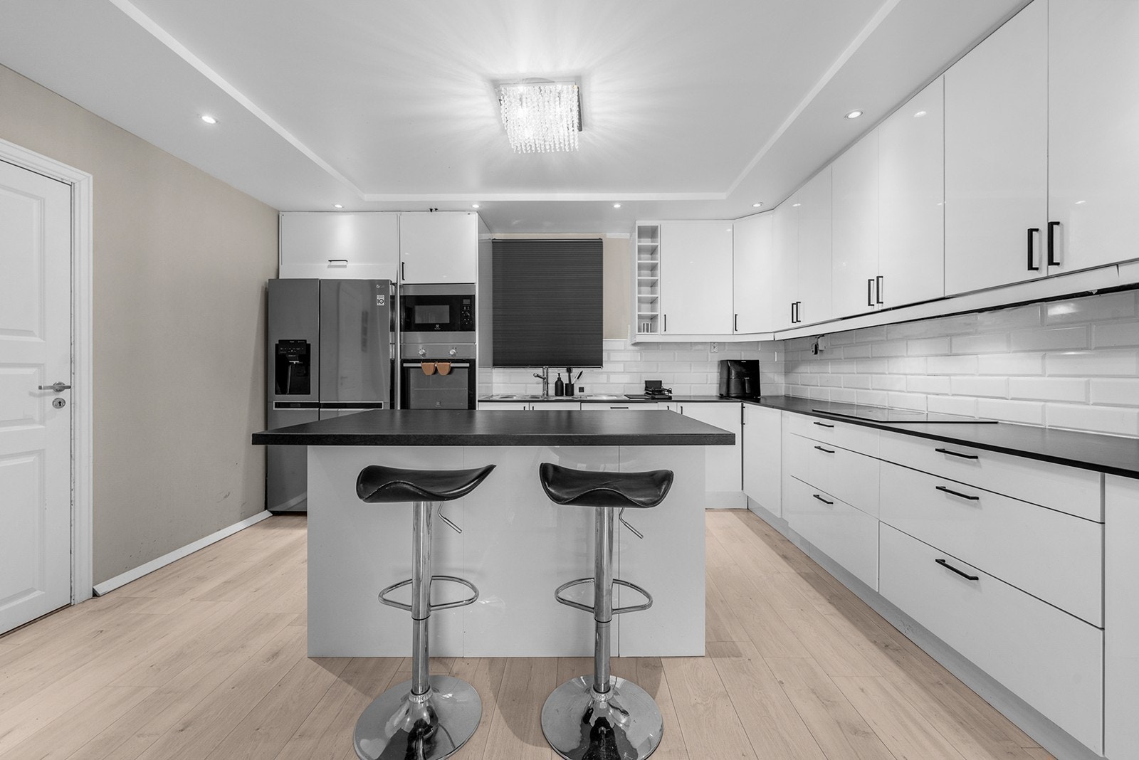 Kjøkkenventilator er integrert i skap over platetoppen med avtrekk ut, og det er downlights i taket. Galleribilde